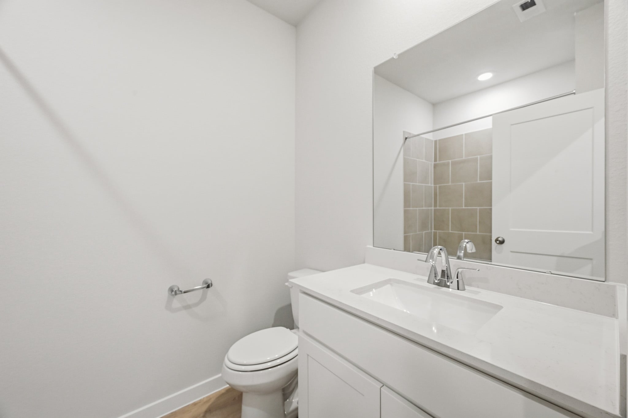 A bathroom with a sink toilet and mirror.