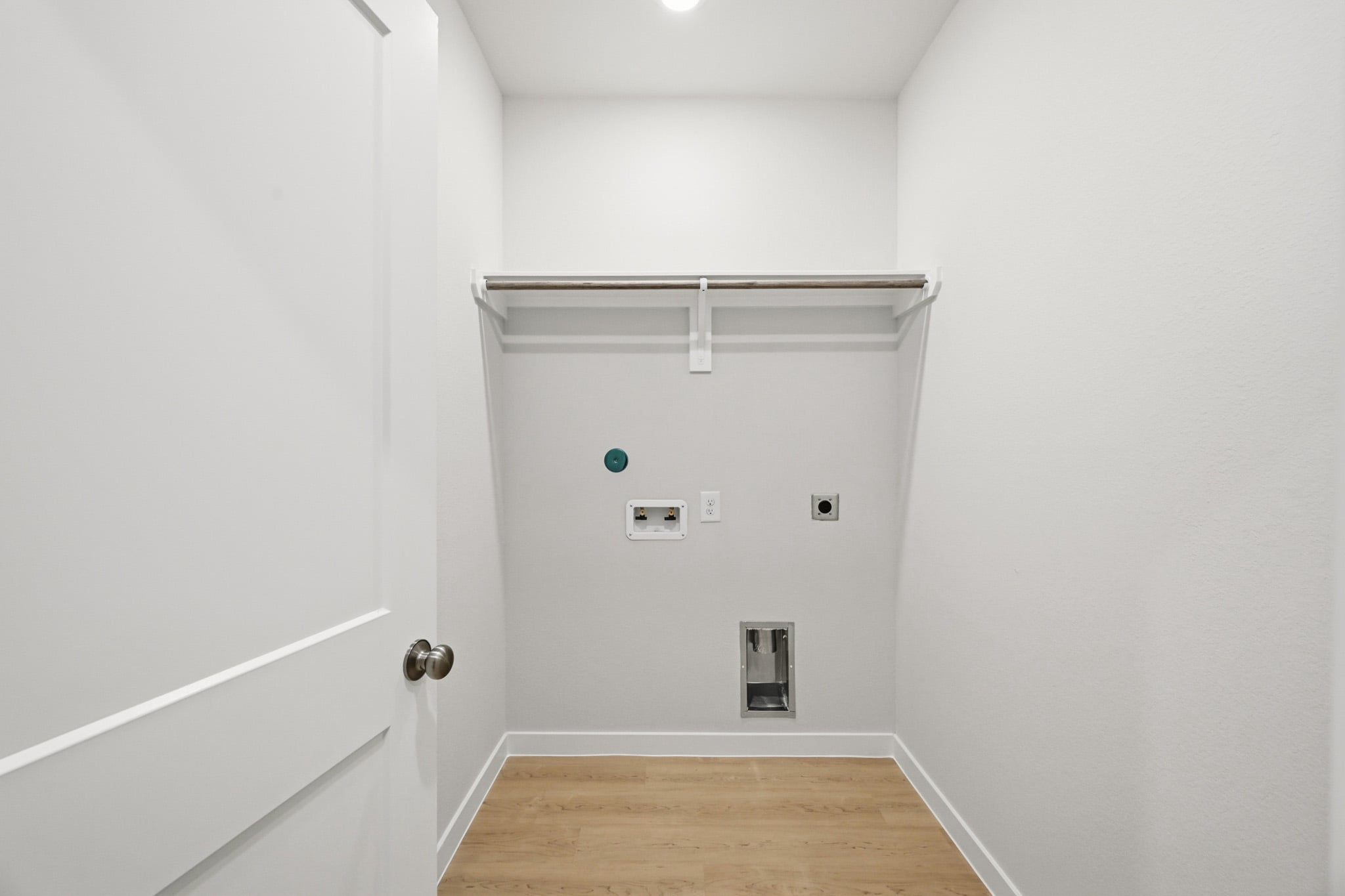 A white room with a wood floor.