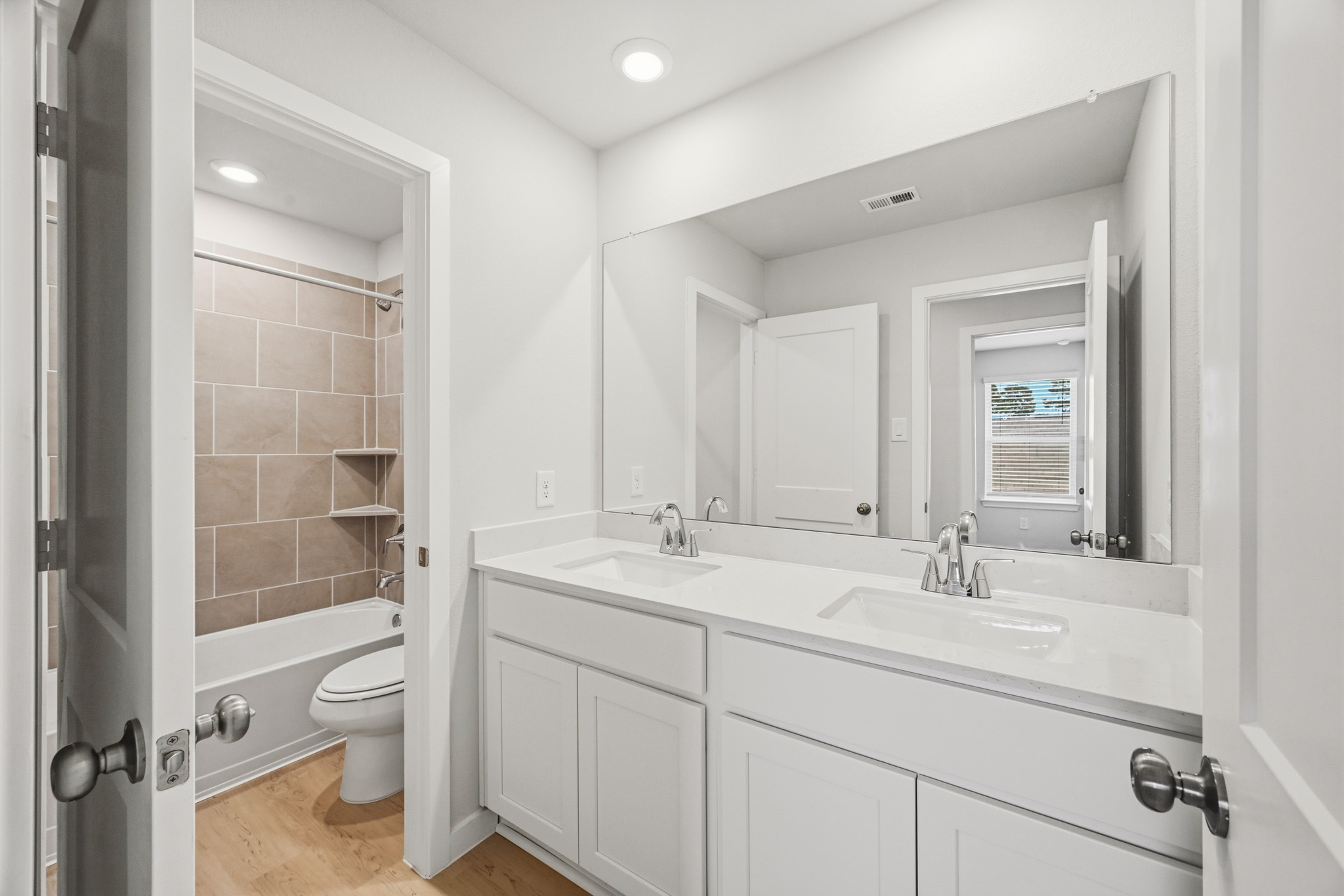 A bathroom with a sink toilet and mirror.