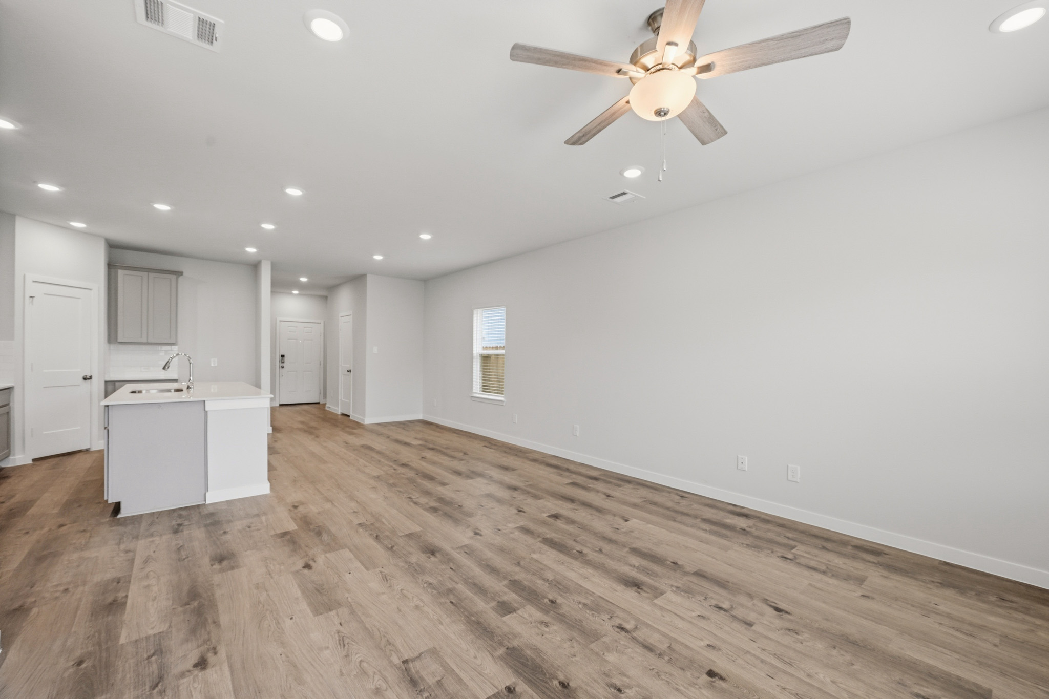 A room with a wood floor and a ceiling fan.