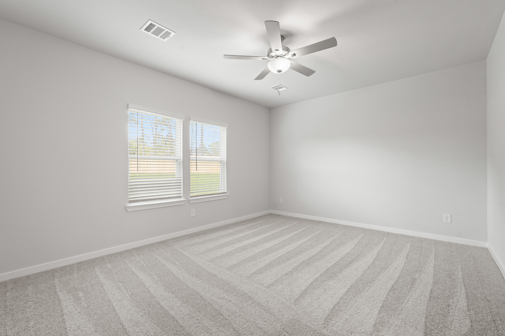 A room with a ceiling fan and a window.