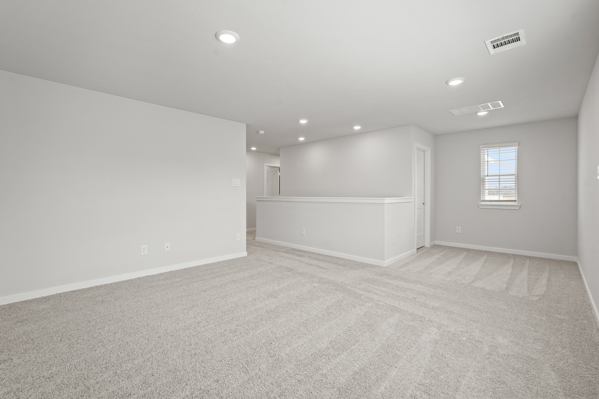A room with a carpet and a window.