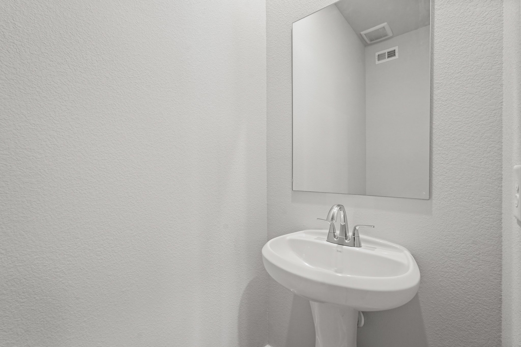 A bathroom with a mirror and sink.