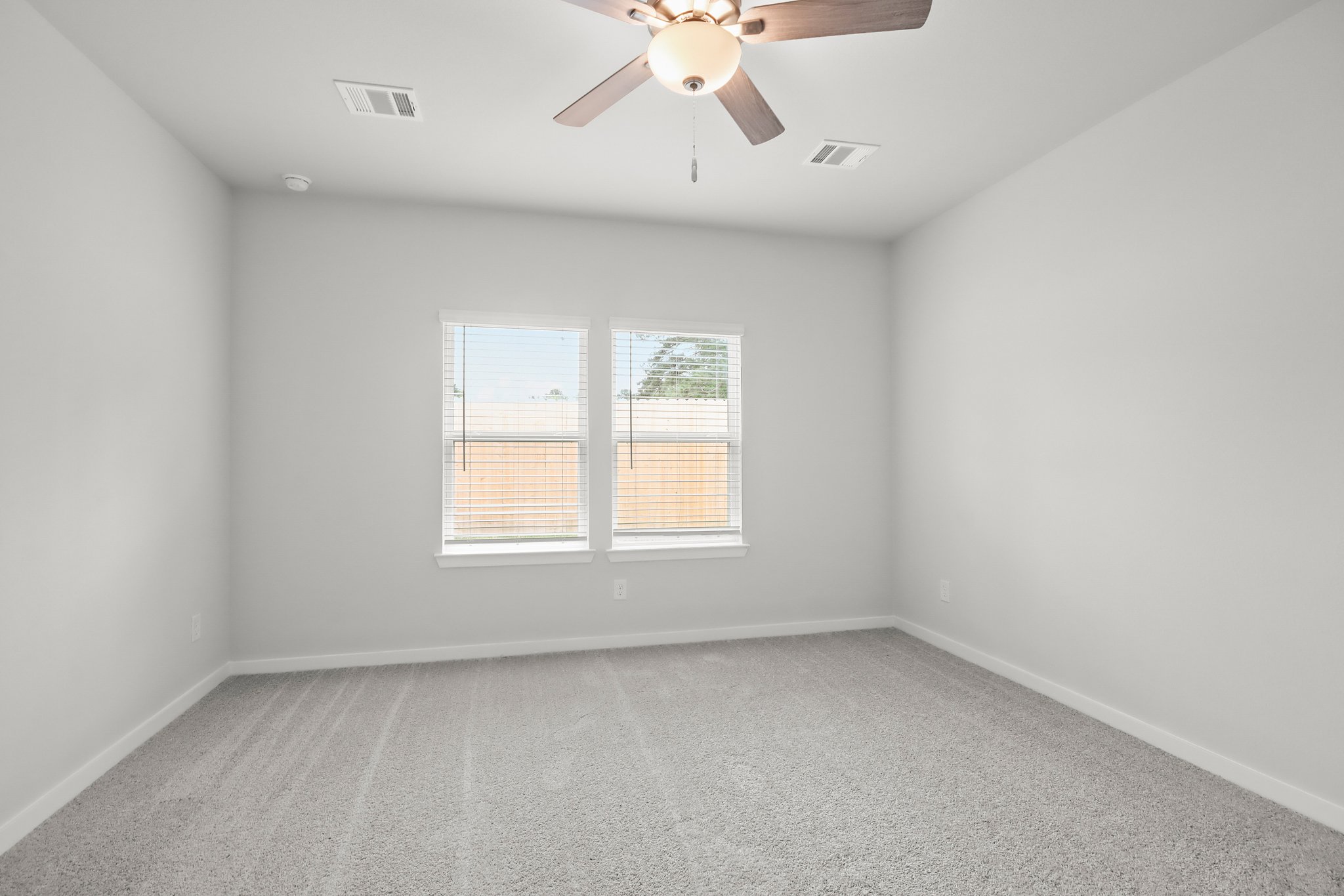 A room with a ceiling fan and a window.