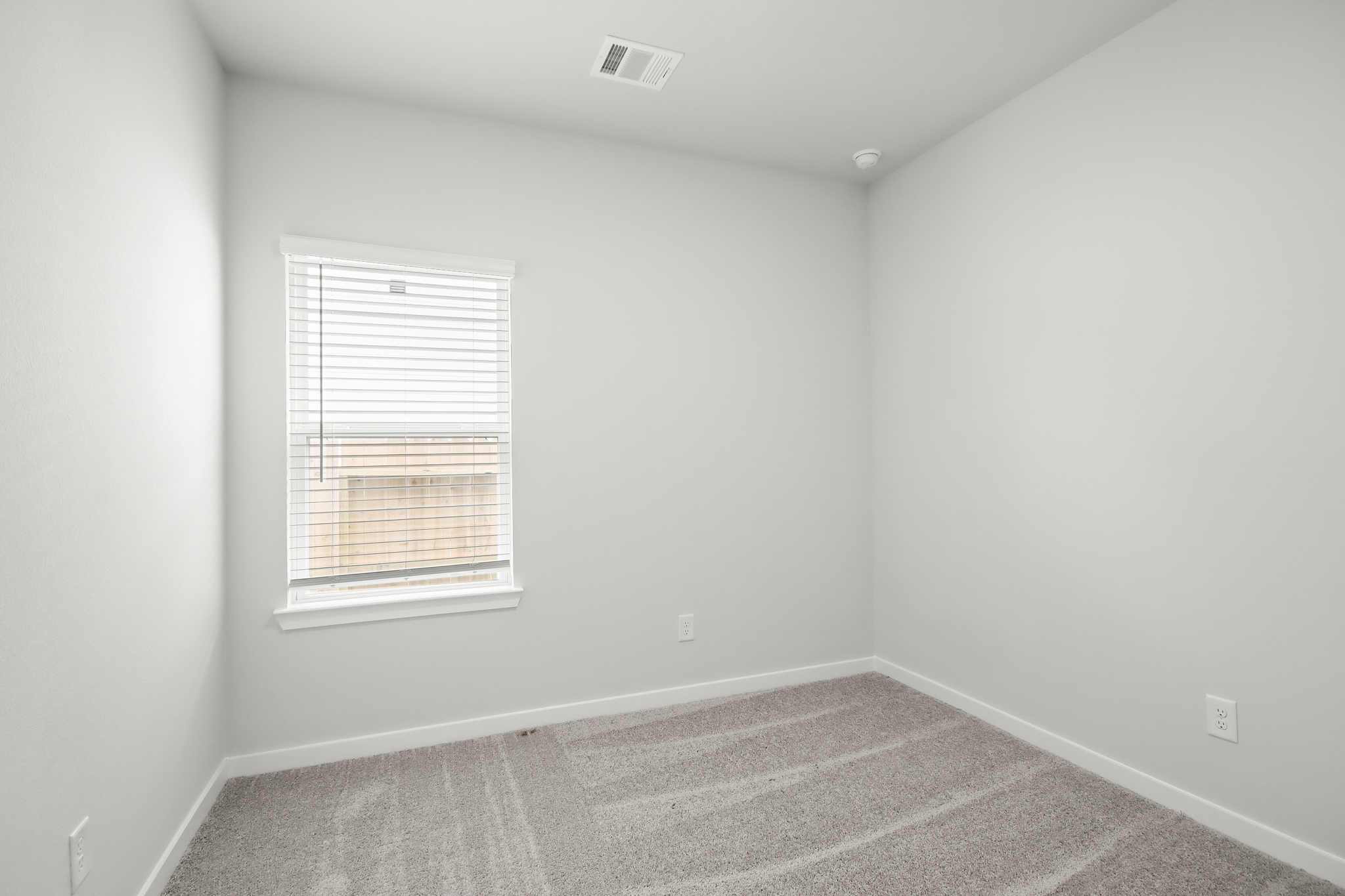 A room with a window and a rug.