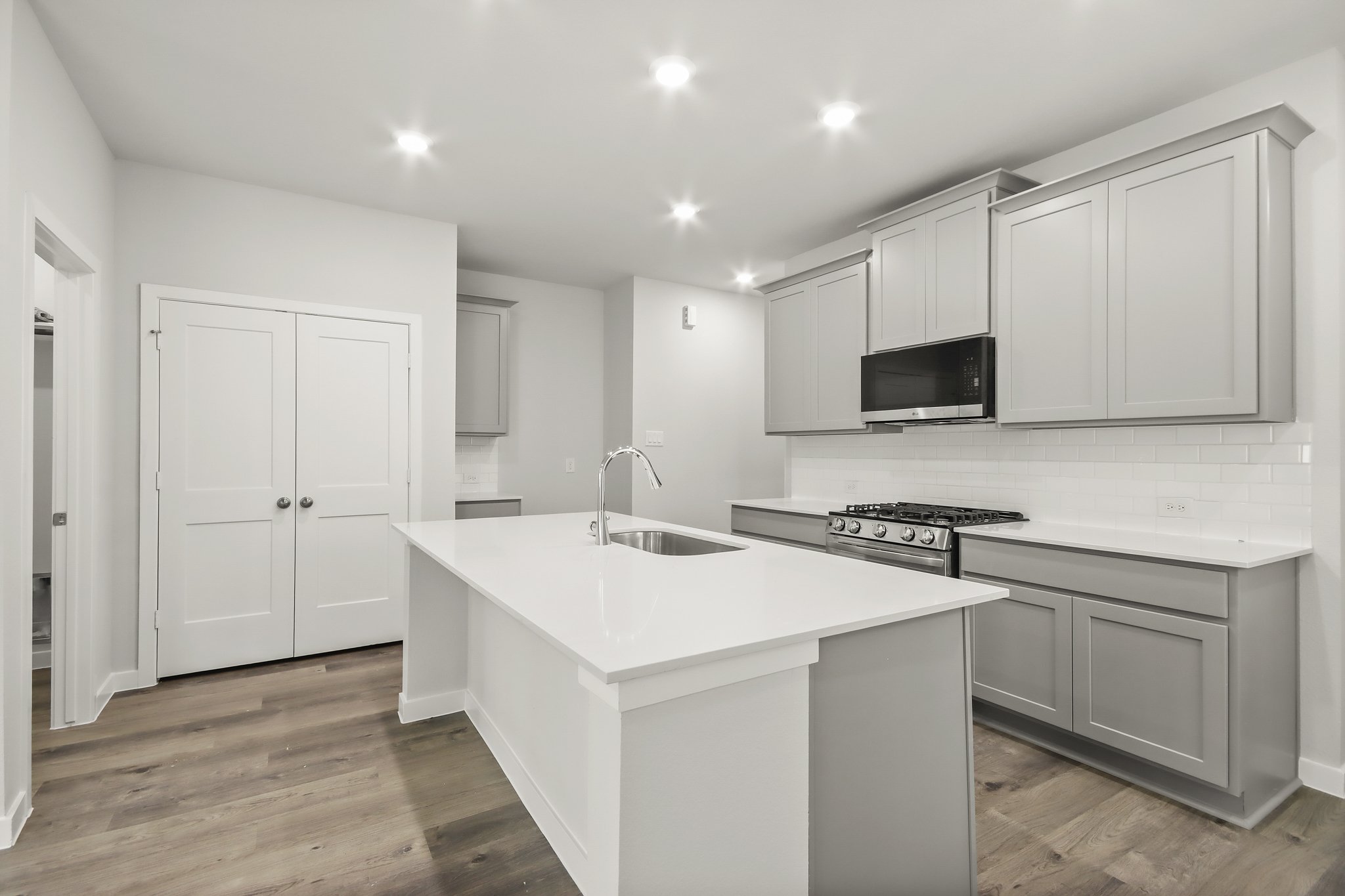 A kitchen with white cabinets.