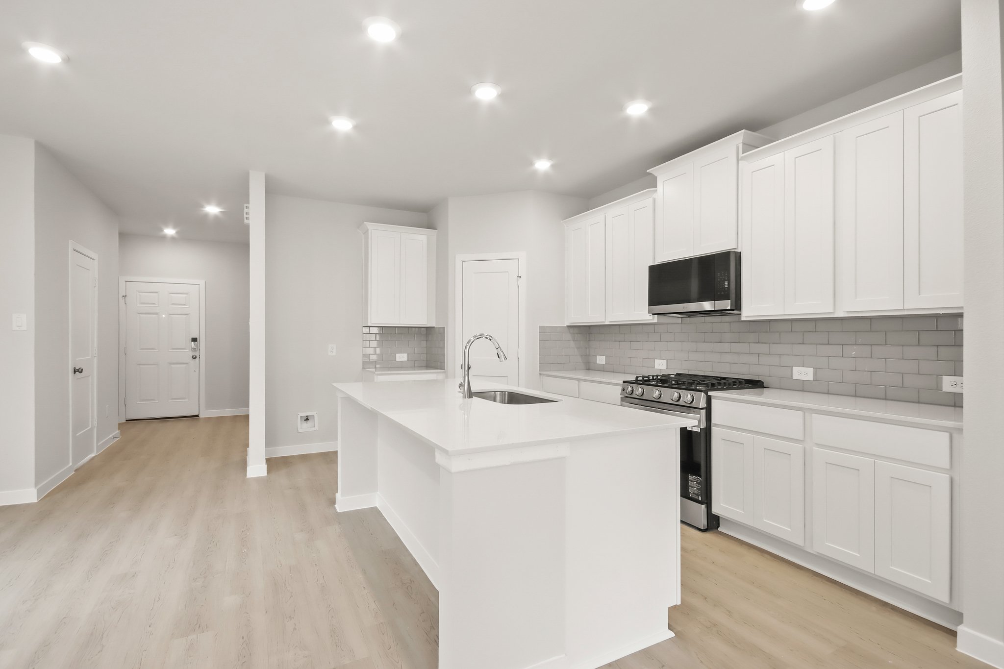 A kitchen with white cabinets.