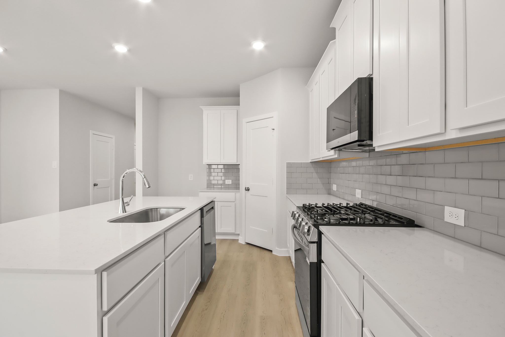 A kitchen with white cabinets.
