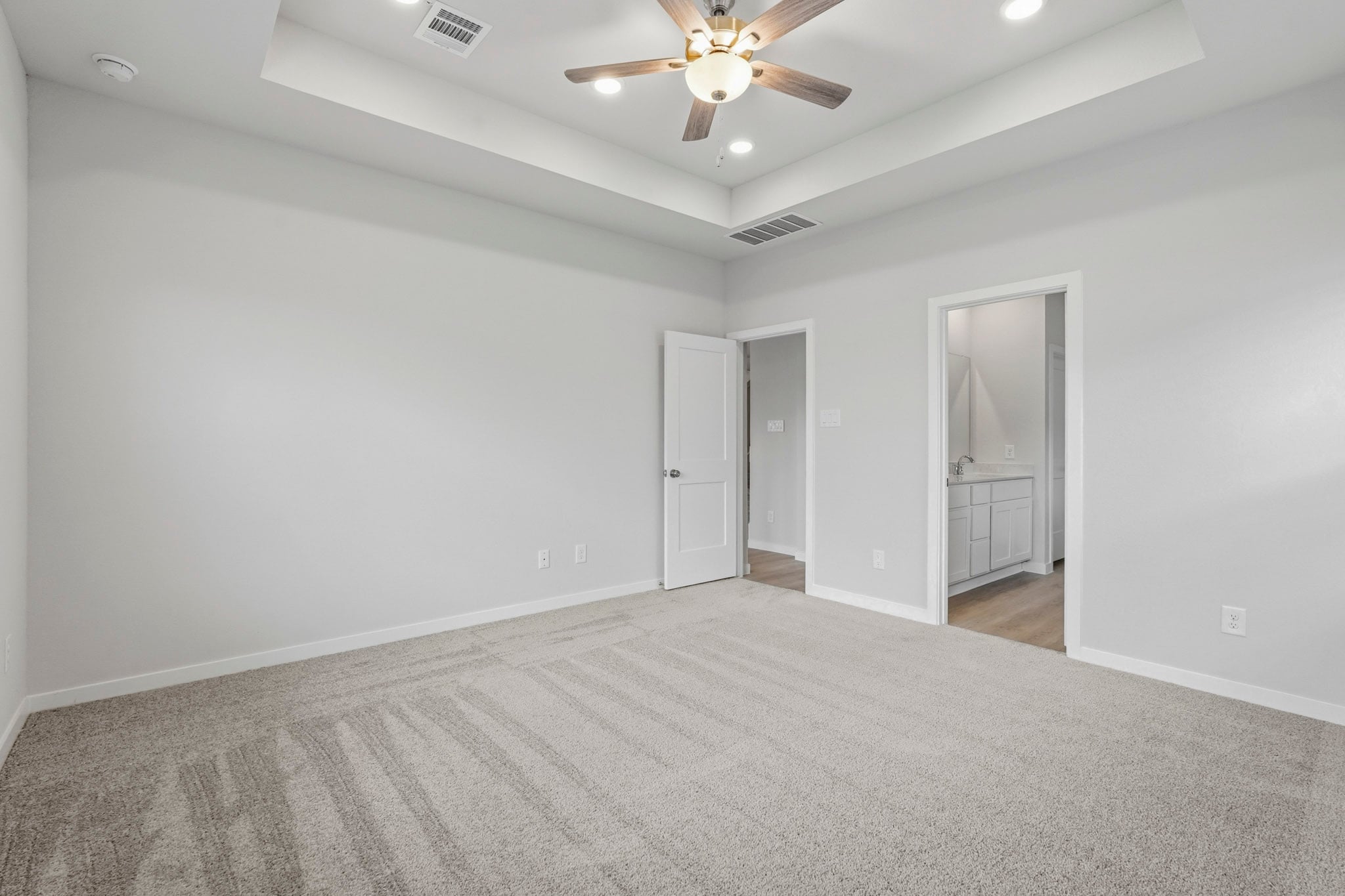 A room with a ceiling fan and a door.