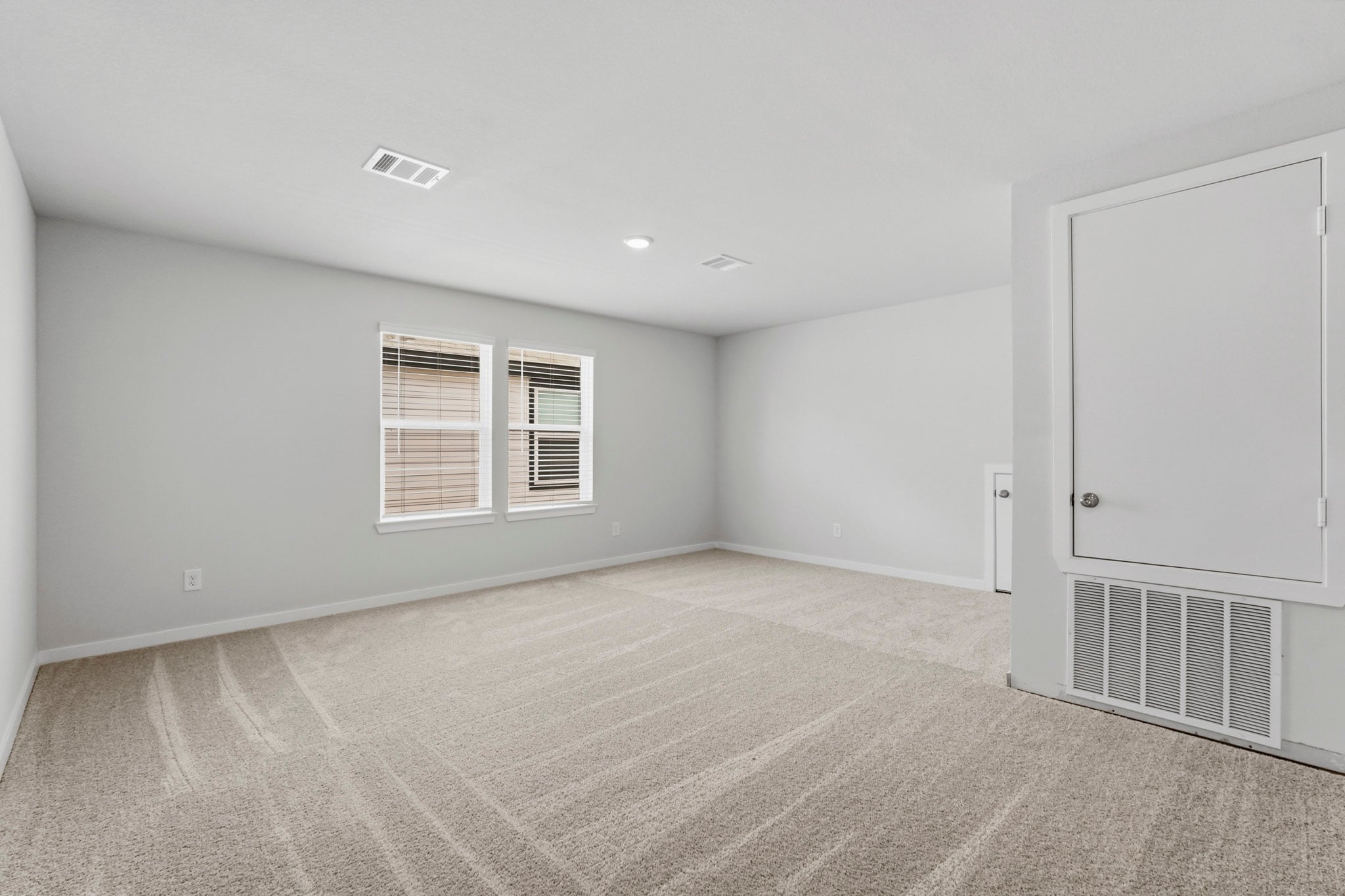 A room with a white door and a white wall.