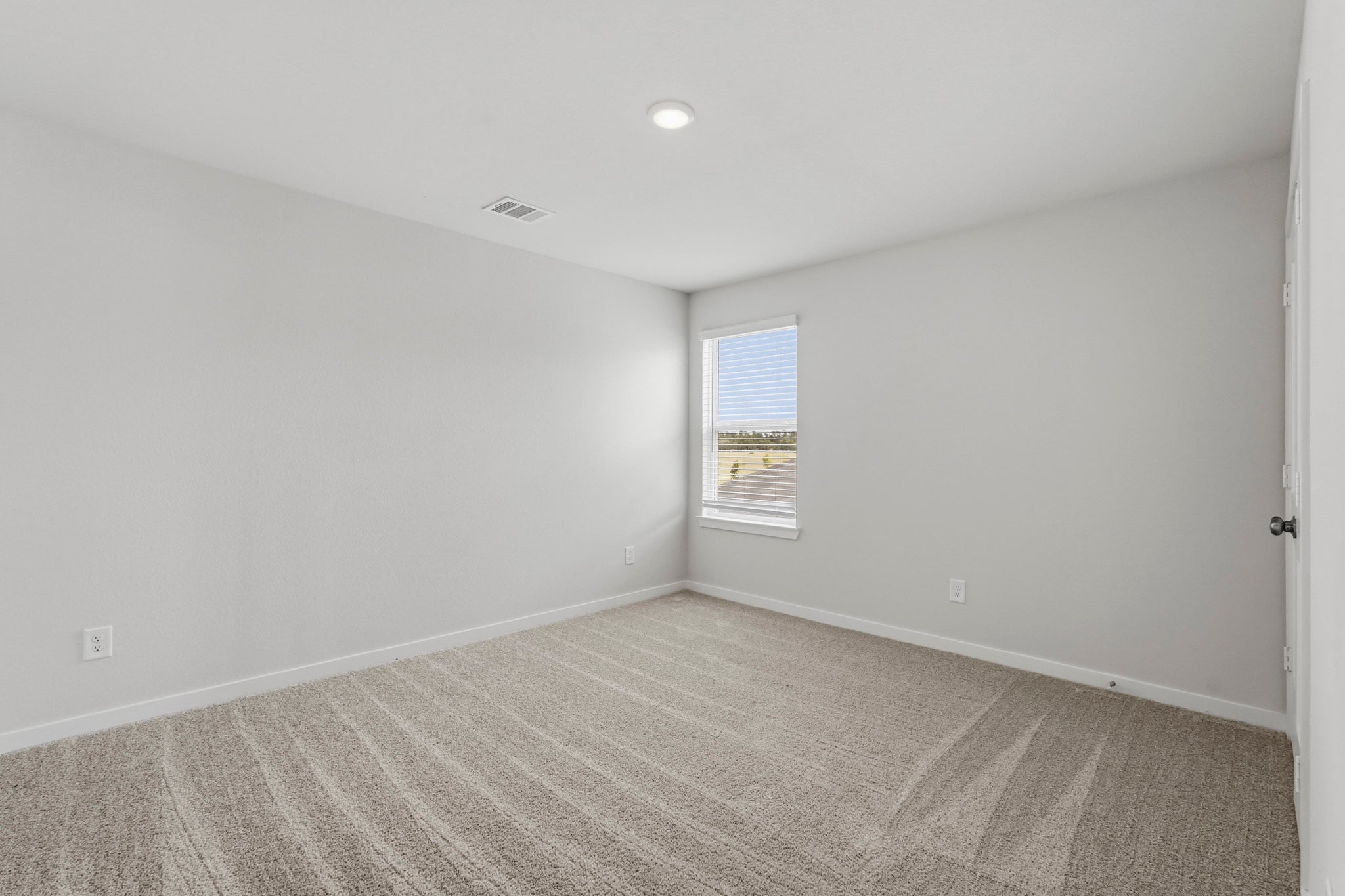 A room with a carpet and a window.