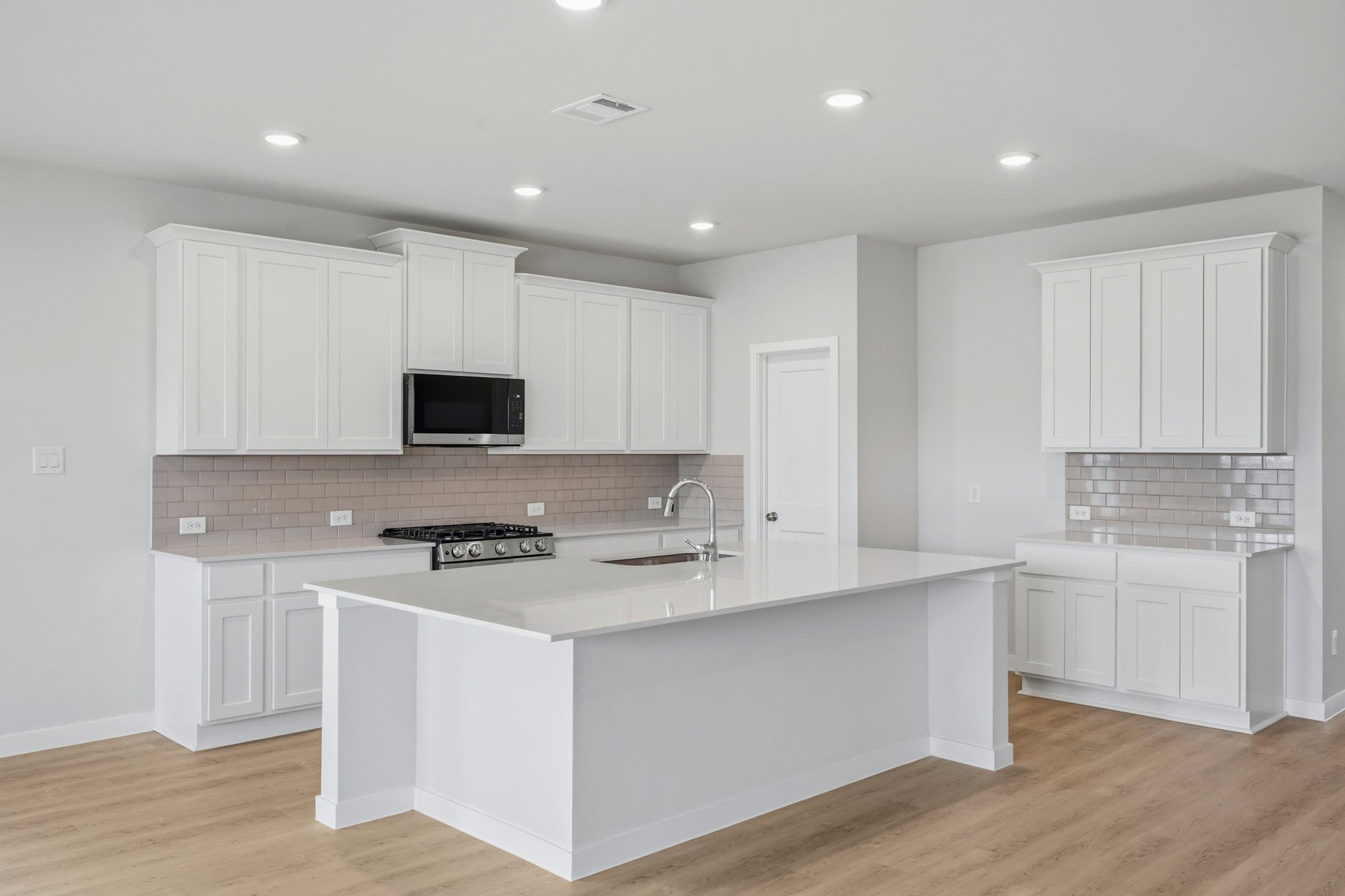 A kitchen with white cabinets.