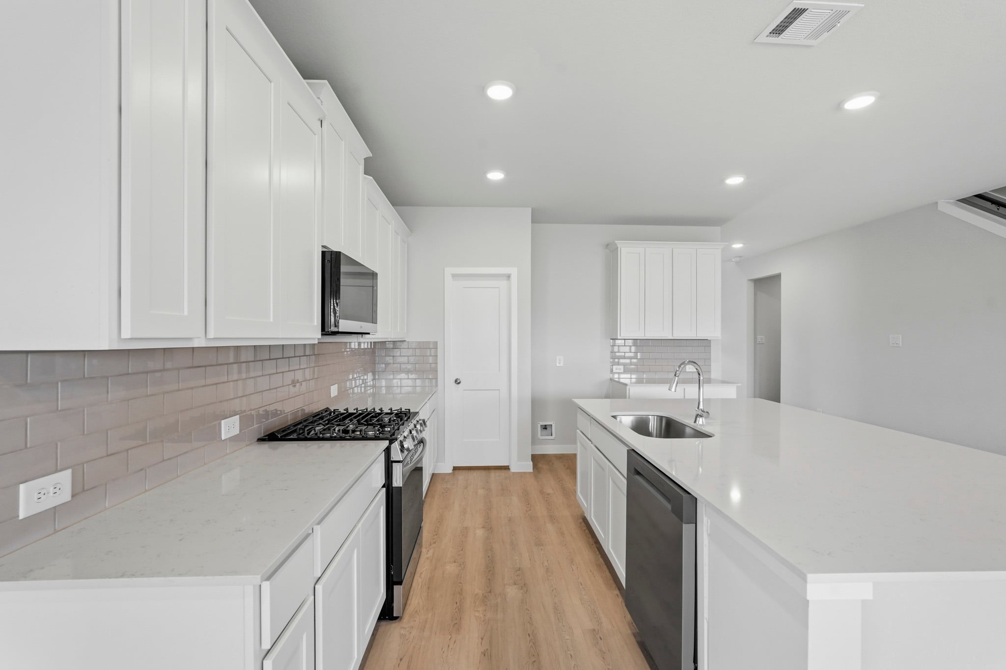 A kitchen with white cabinets.