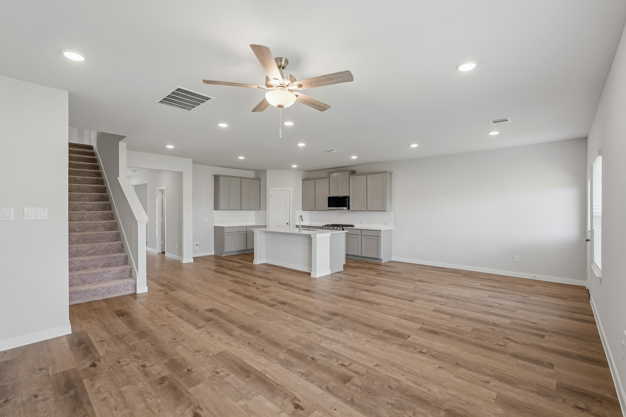 A large empty room with a wood floor and a wood floor.