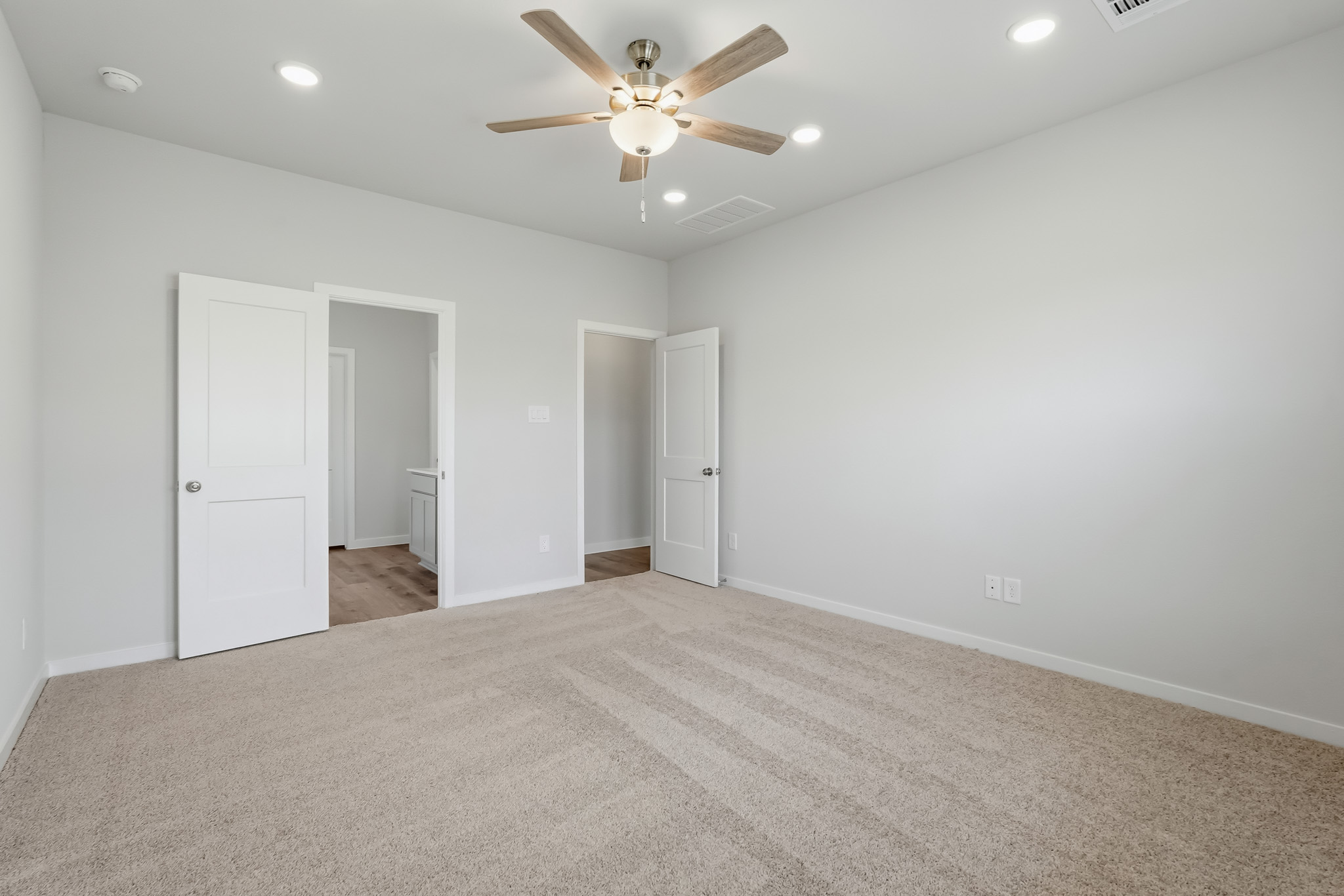 A room with white walls and a ceiling fan.