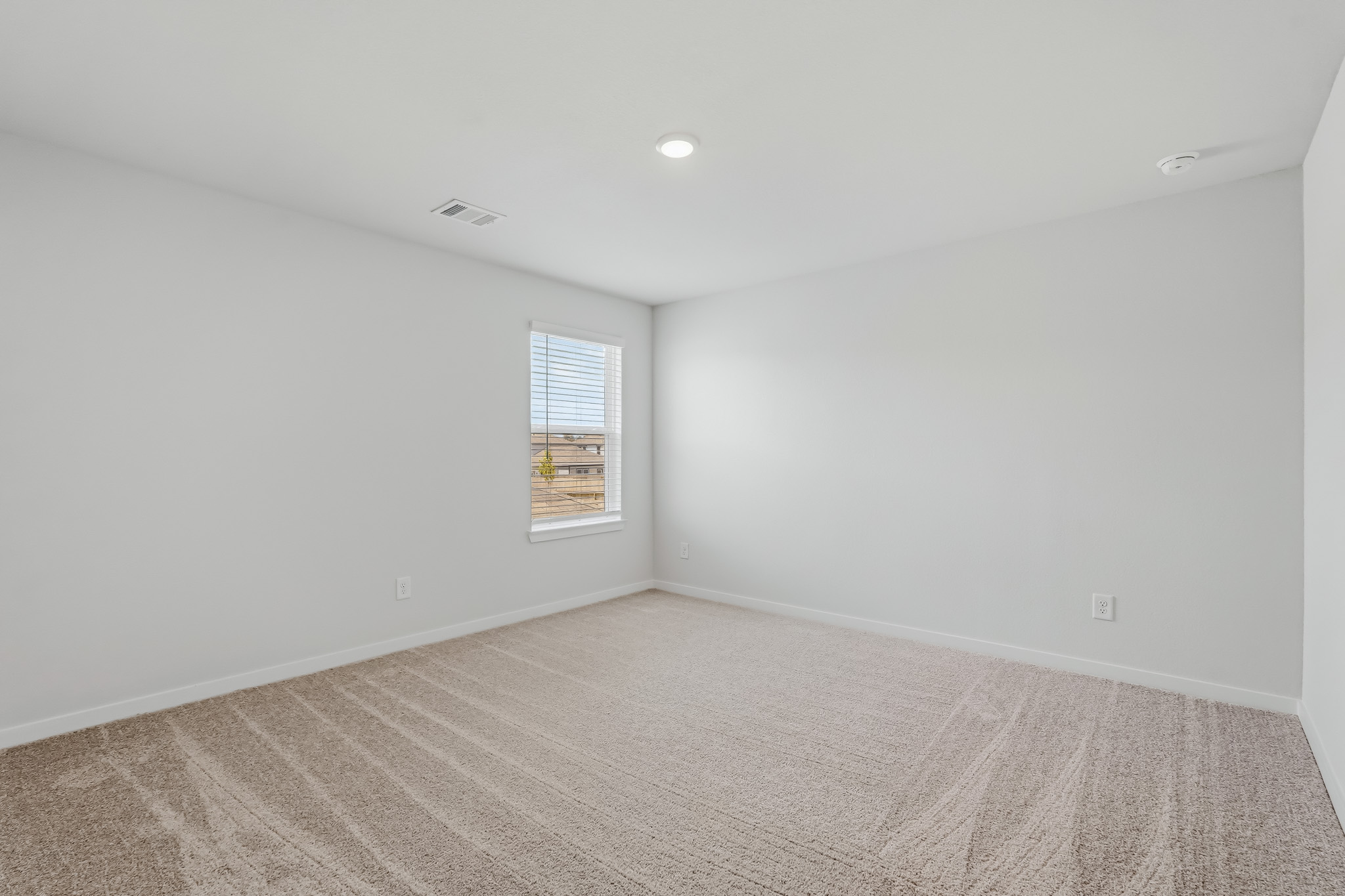 A room with a window and carpet.
