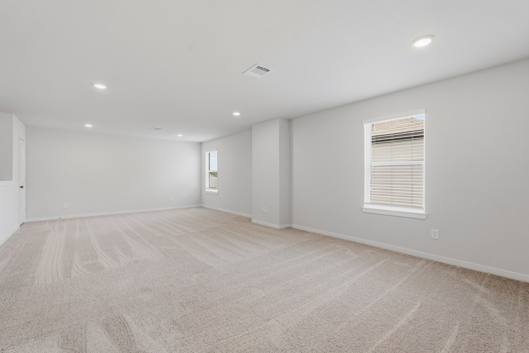 A room with a carpet and a window.