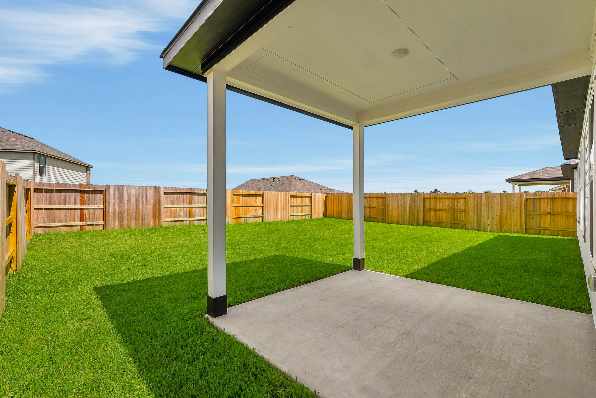 A backyard with a covered patio.
