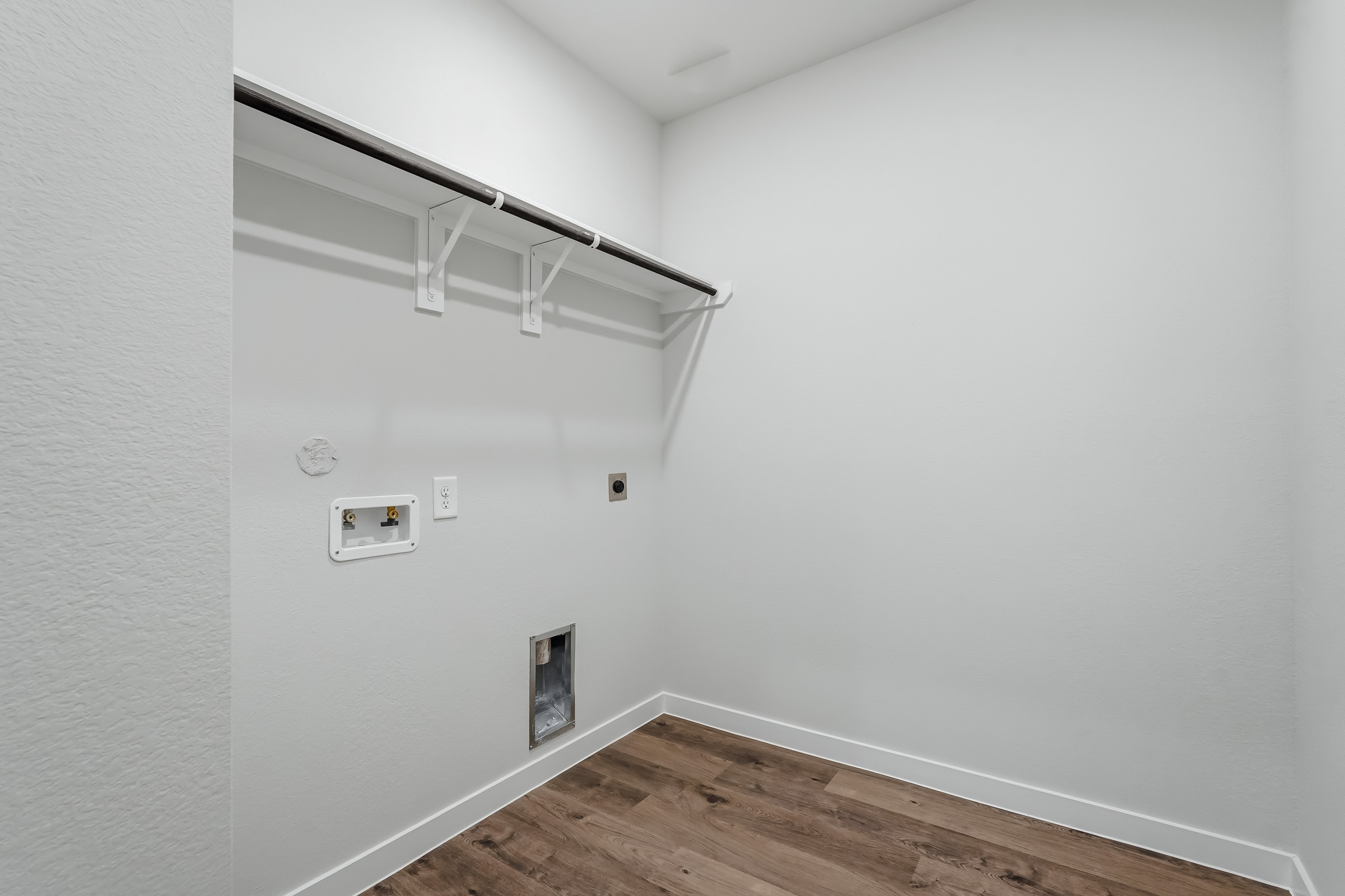A white room with a wood floor and a wood floor.