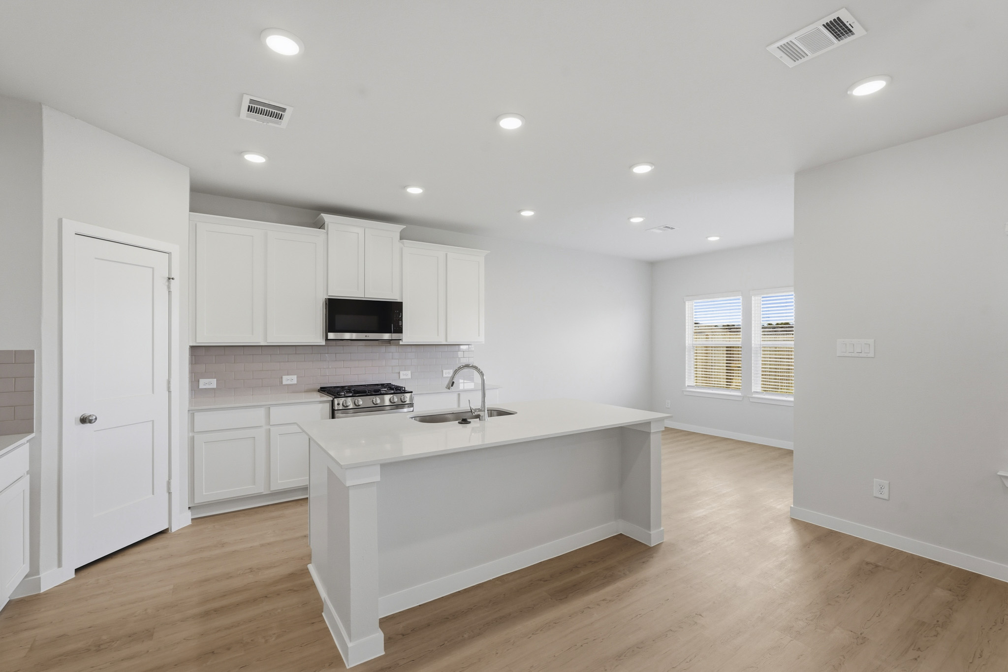 A kitchen with white cabinets.