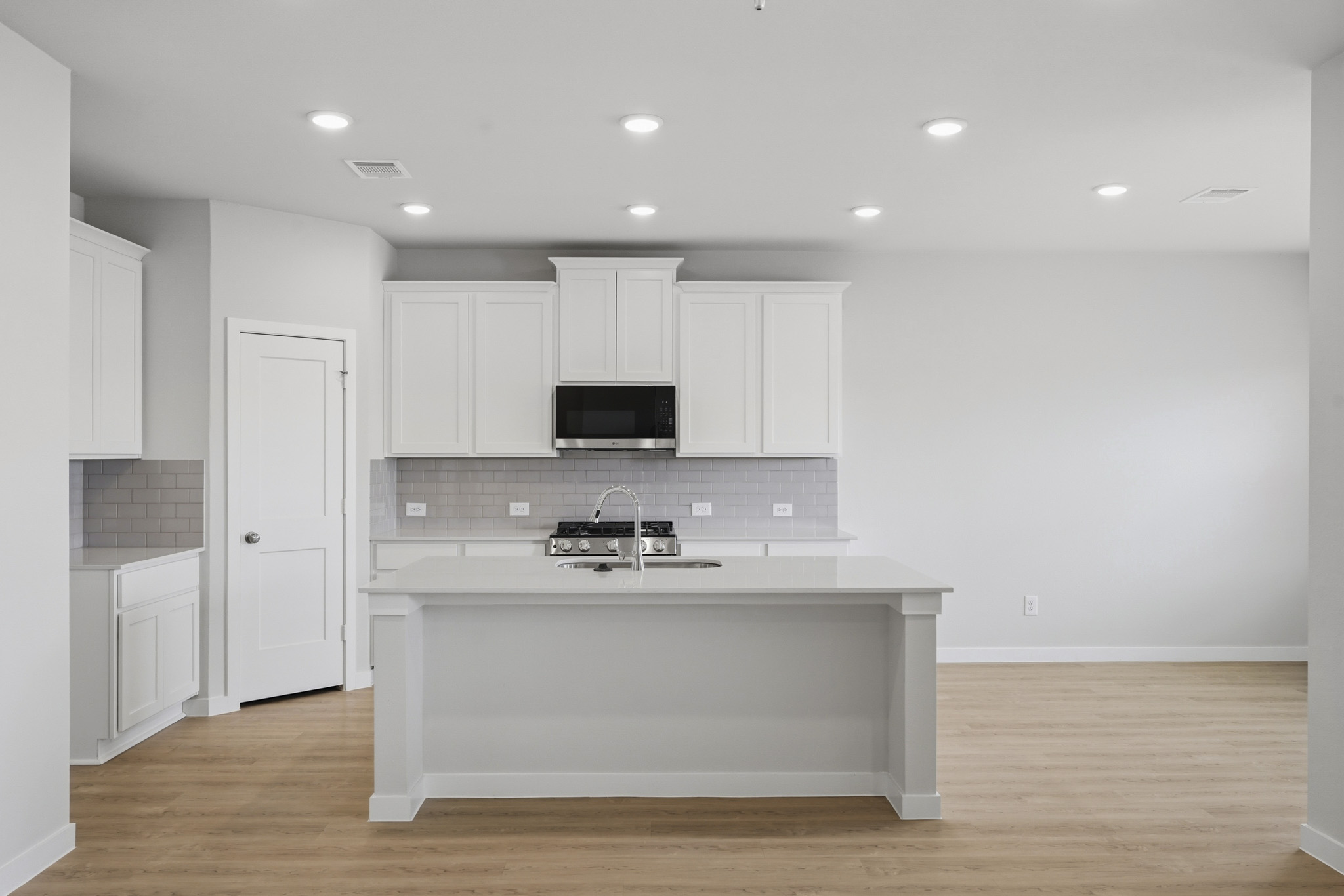A kitchen with white cabinets.
