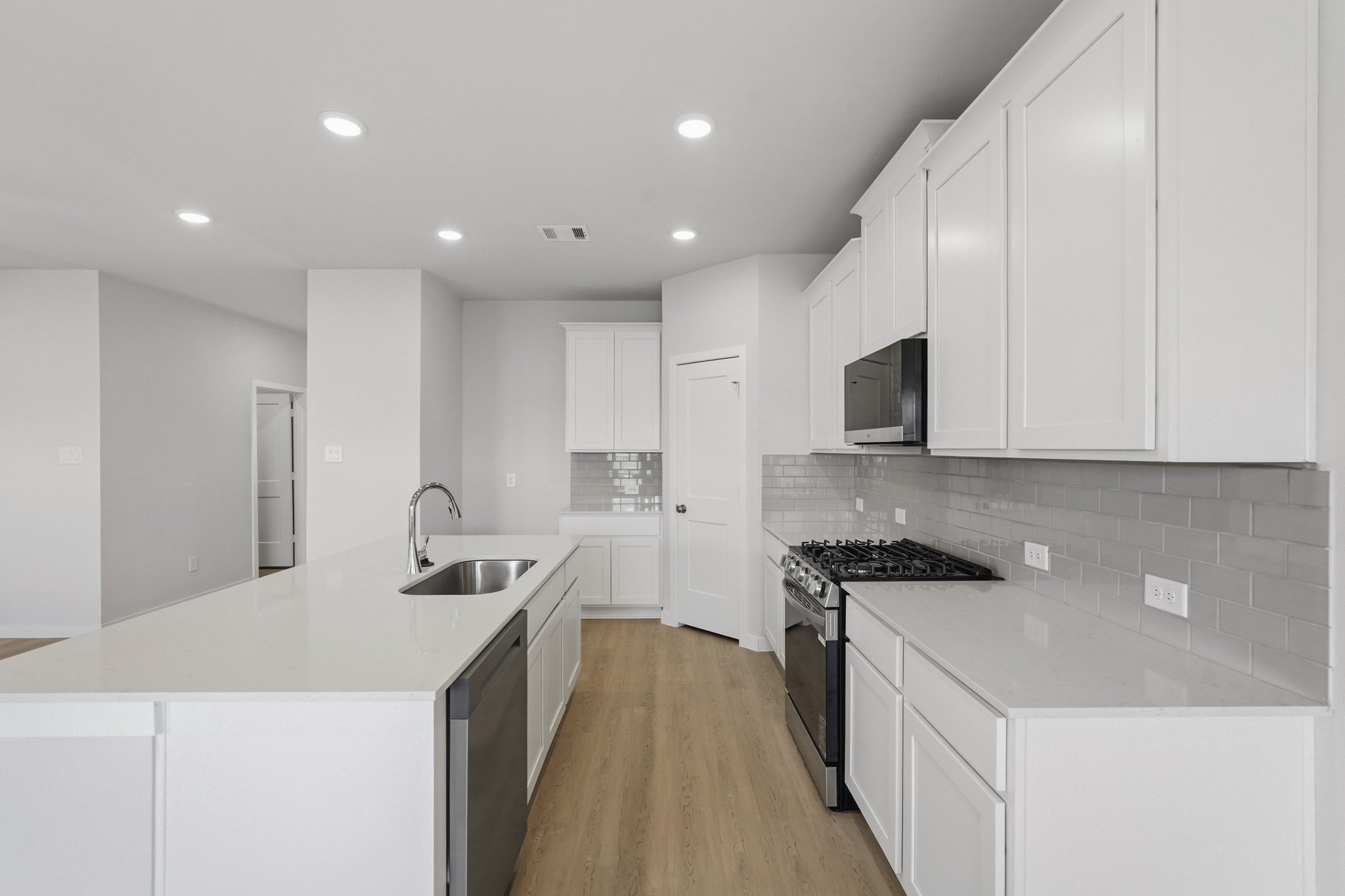 A kitchen with white cabinets.