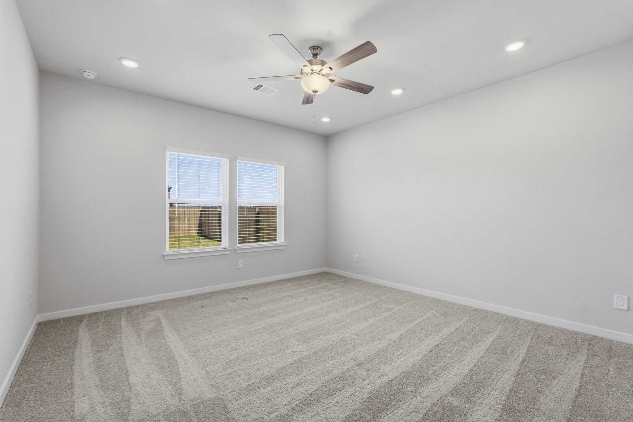 A room with a ceiling fan and a window.