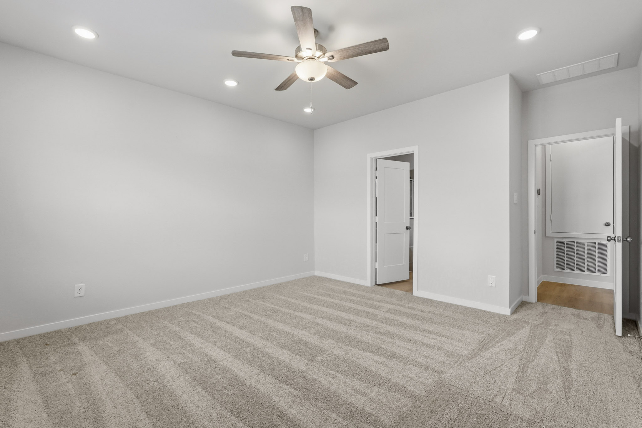 A room with a ceiling fan and a door.