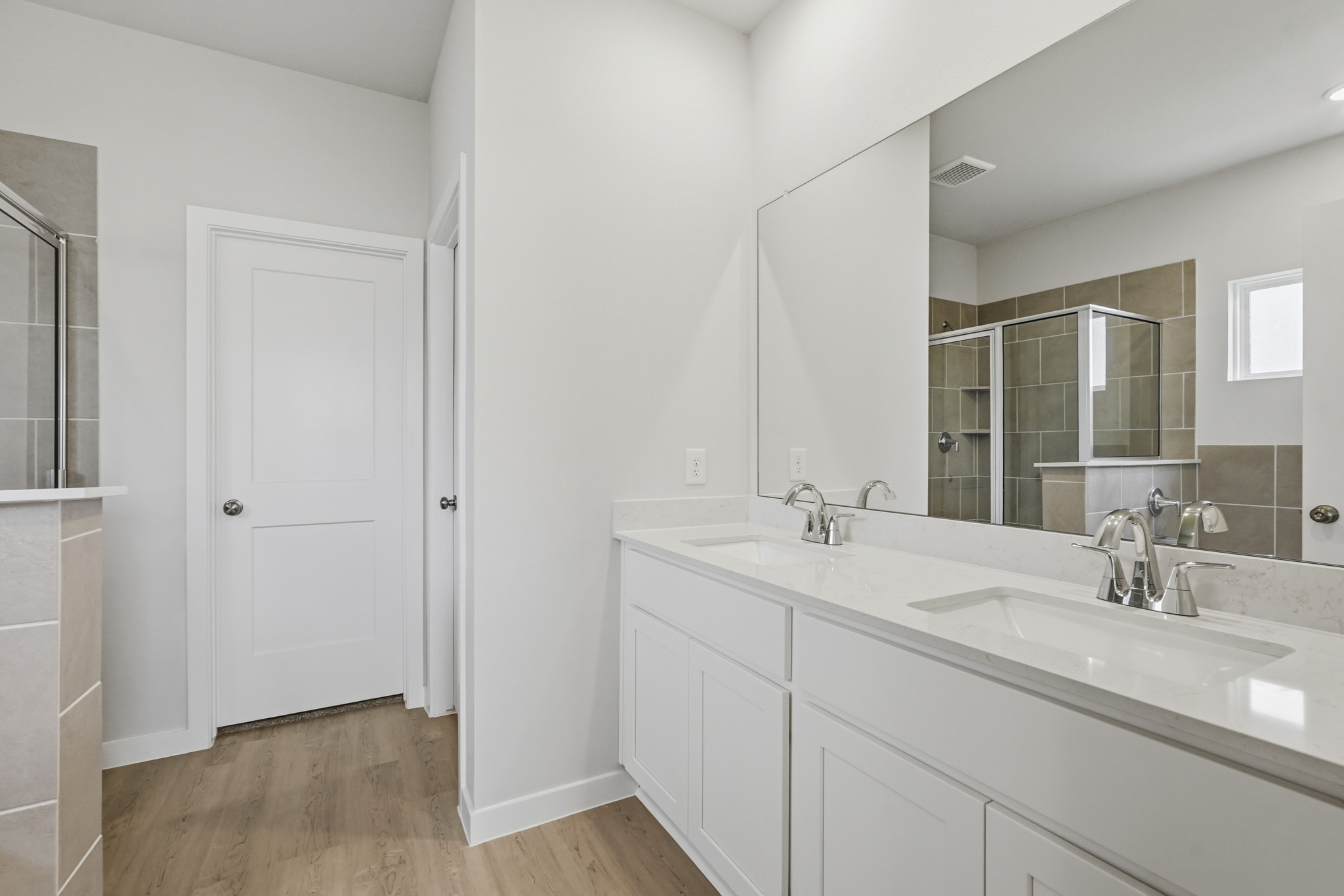 A bathroom with white cabinets.