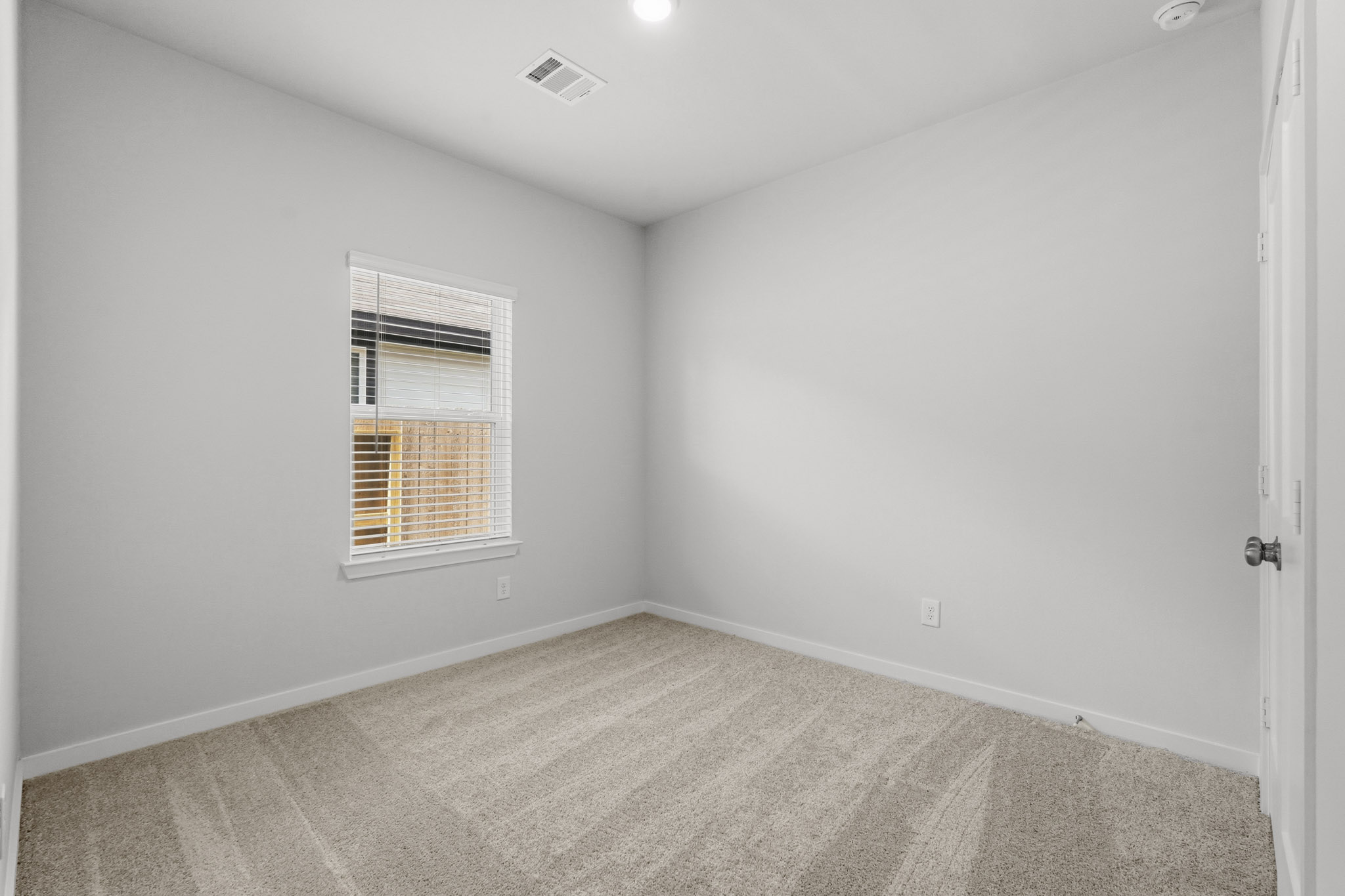 A room with a carpet and a window.