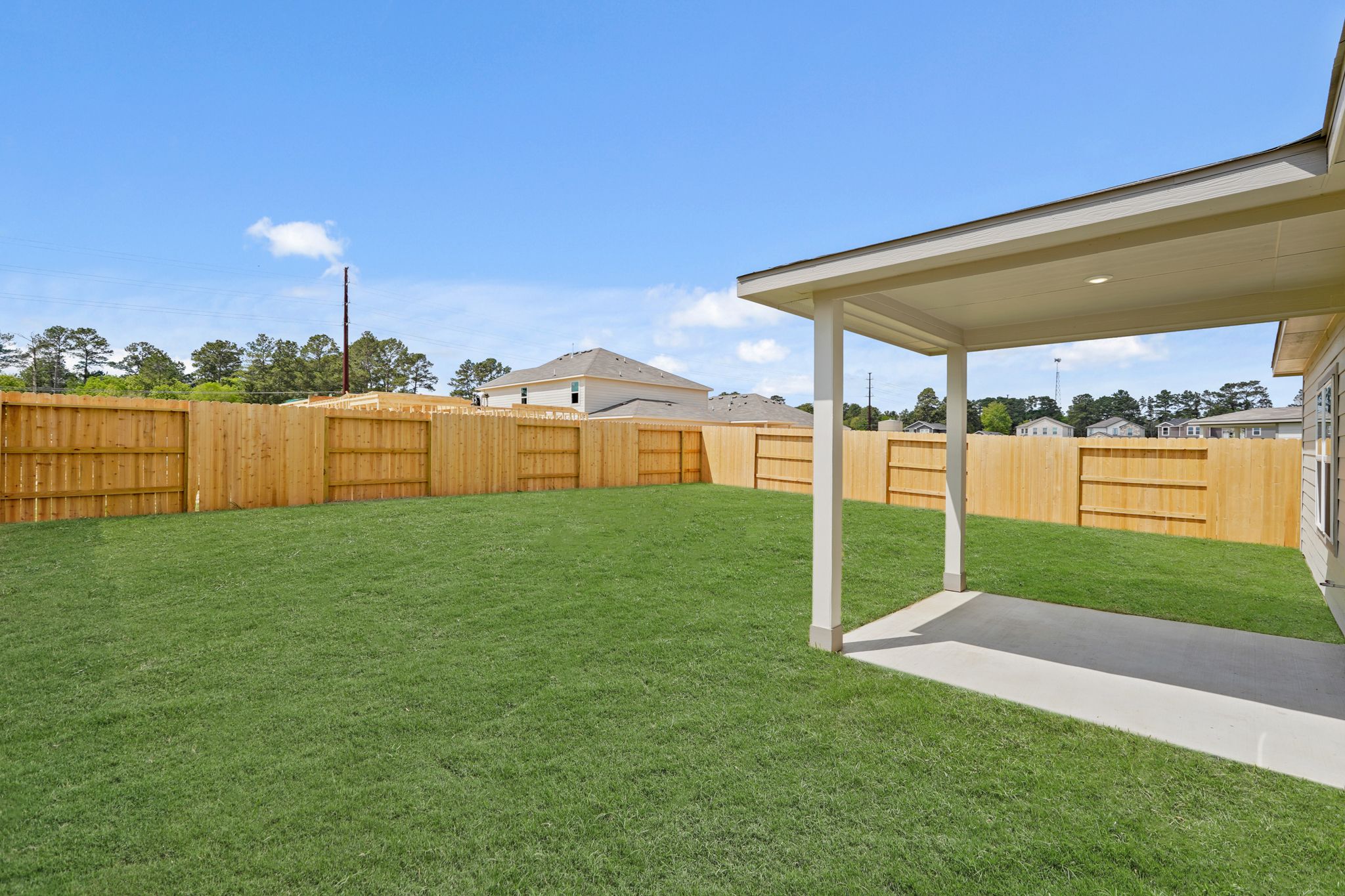 A fenced in yard with a building in the background.