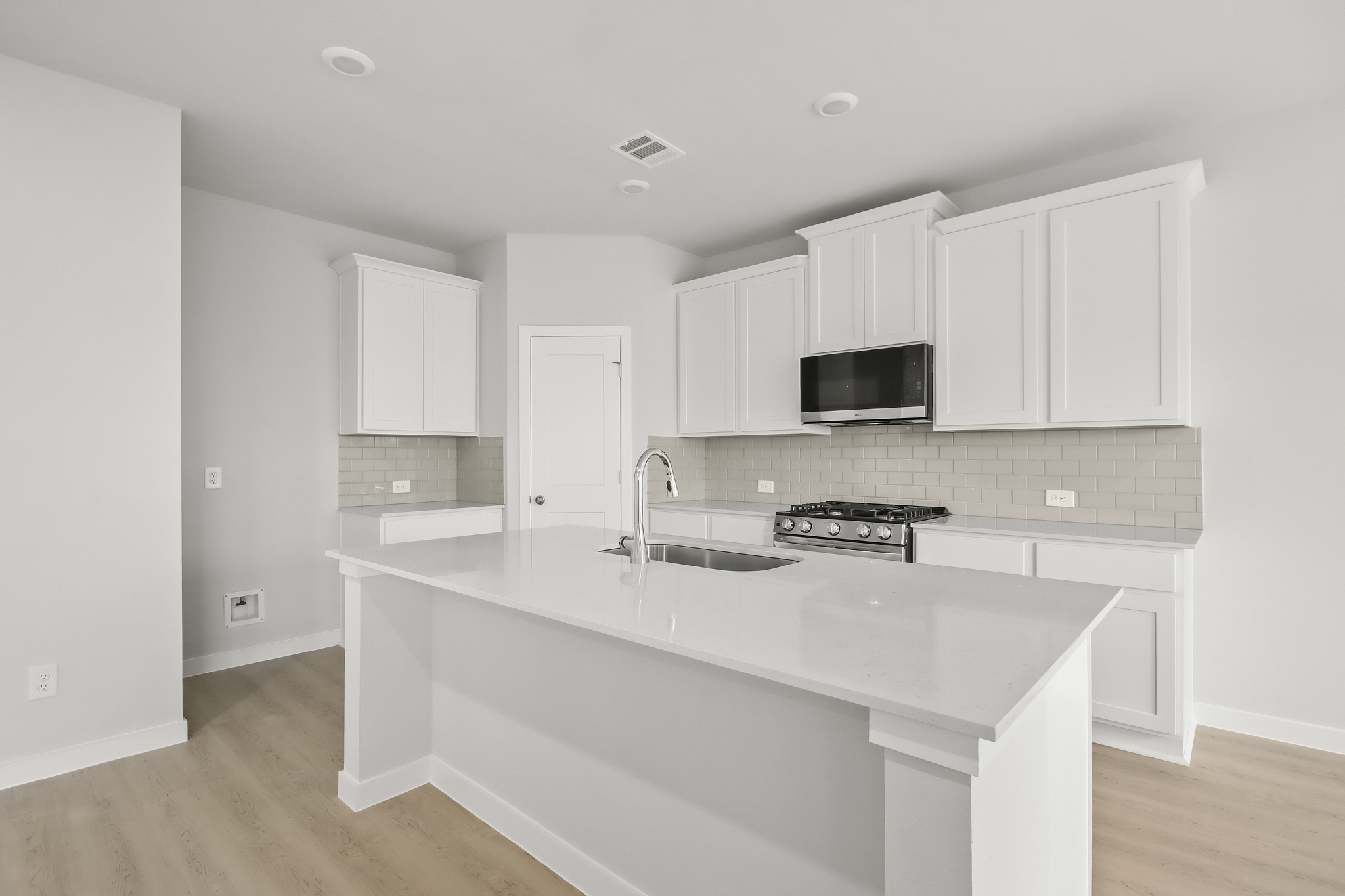A kitchen with white cabinets.