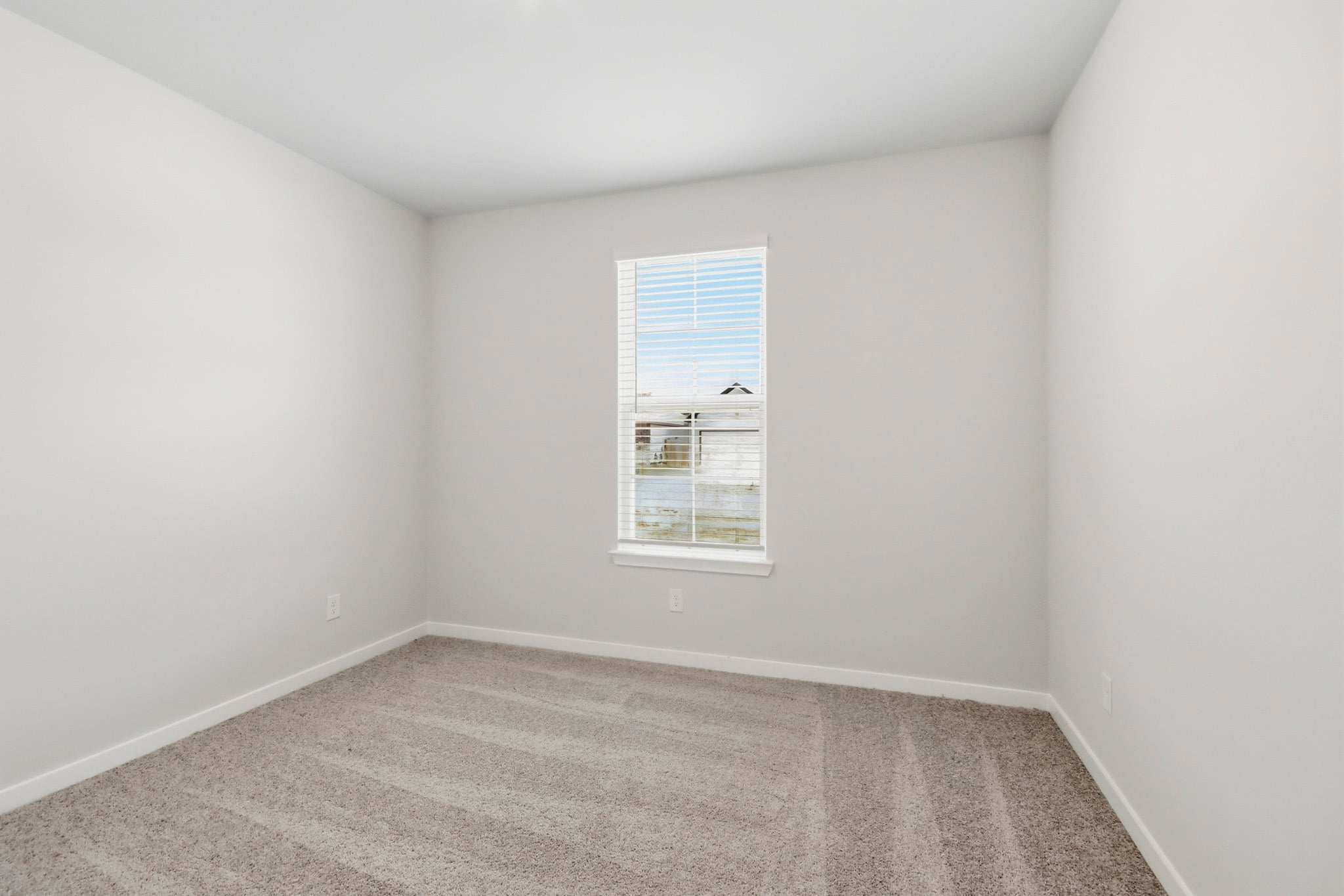 A room with a window and a rug.