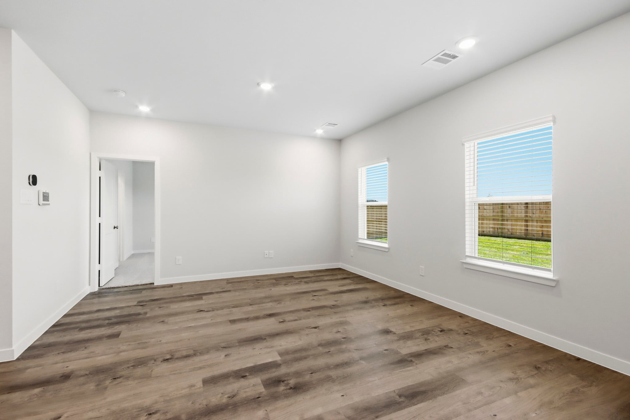 A room with a wood floor and windows.