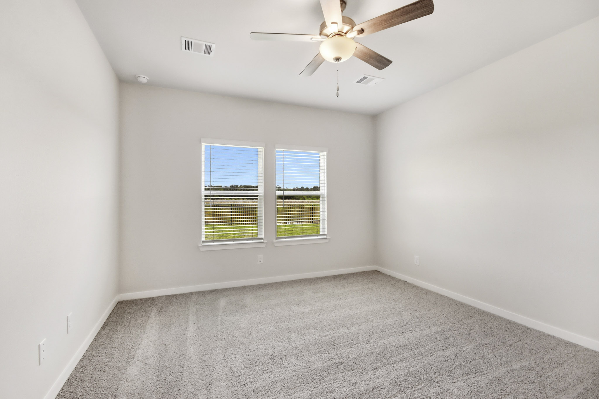 A room with a ceiling fan and a window.