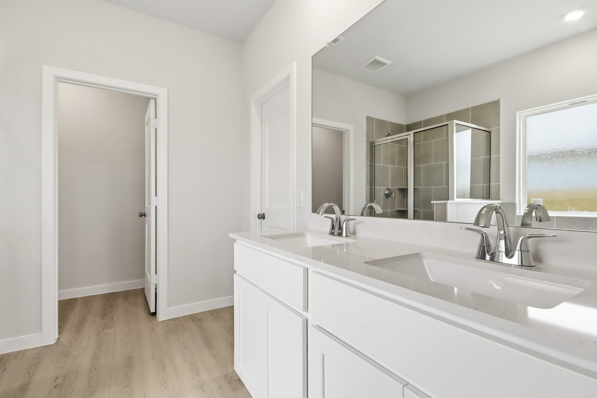 A bathroom with white cabinets.