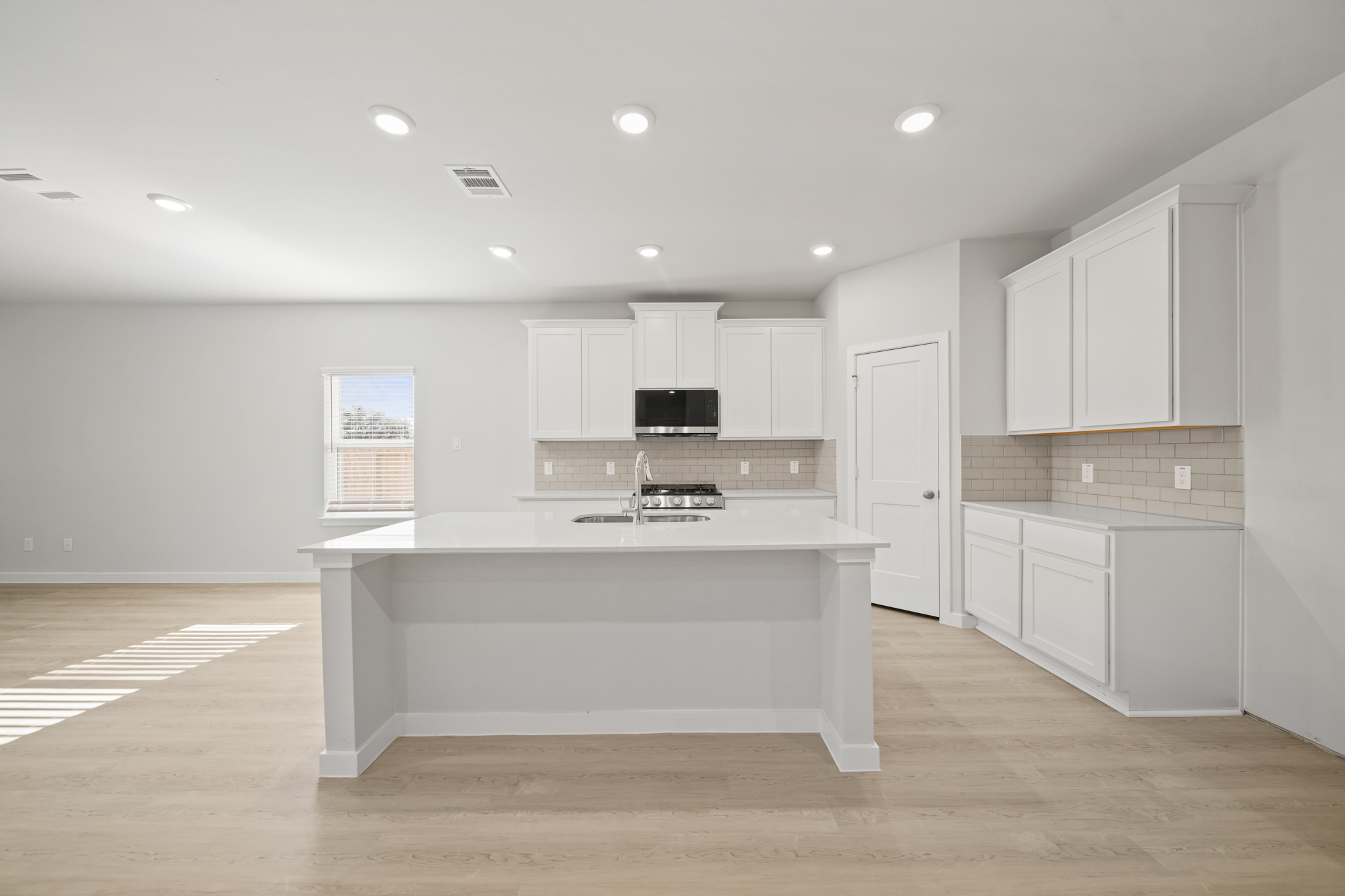 A kitchen with white cabinets.