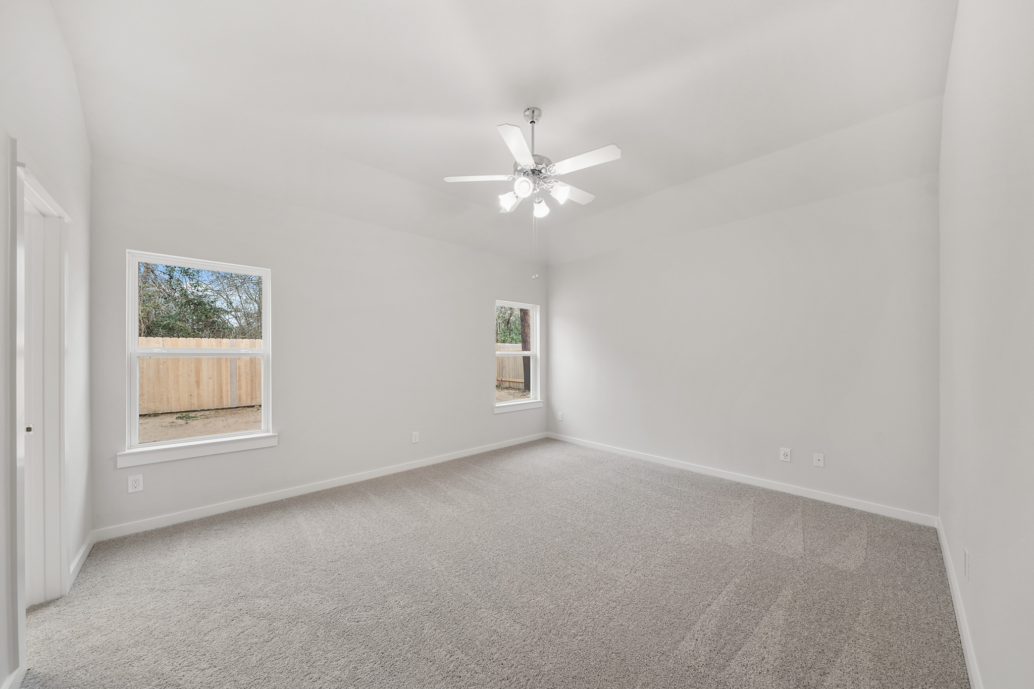A room with a ceiling fan and a window.