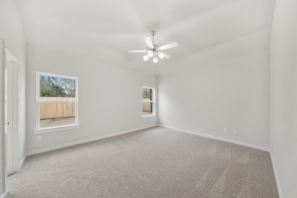 A room with a ceiling fan and a window.