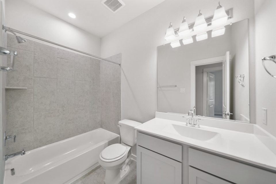 A bathroom with a tub sink and toilet.