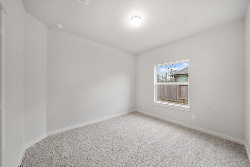 A room with a window and a carpet.