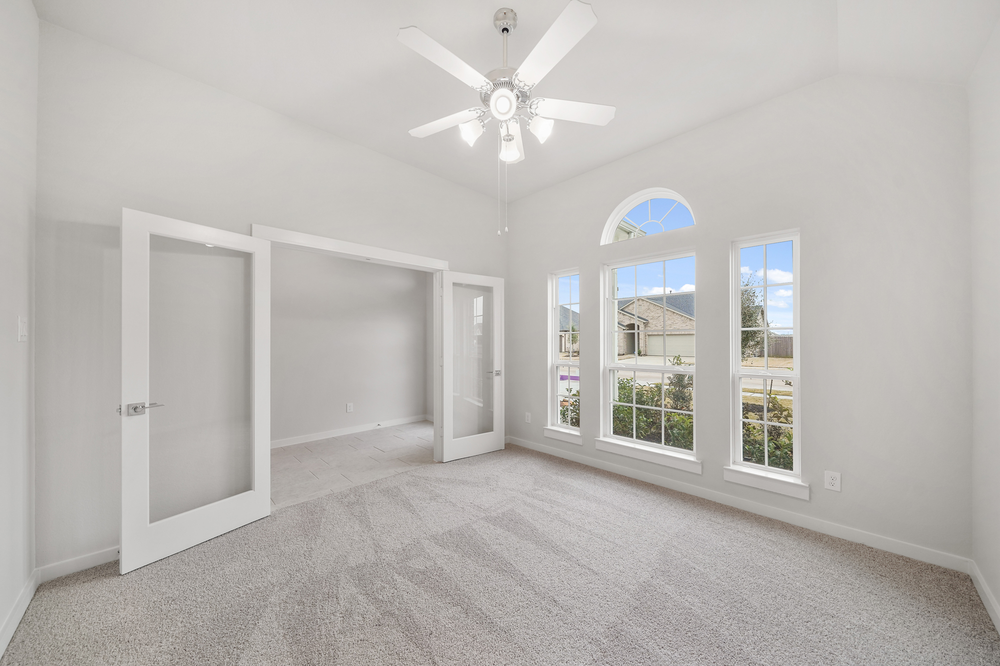 A room with a ceiling fan and a window.