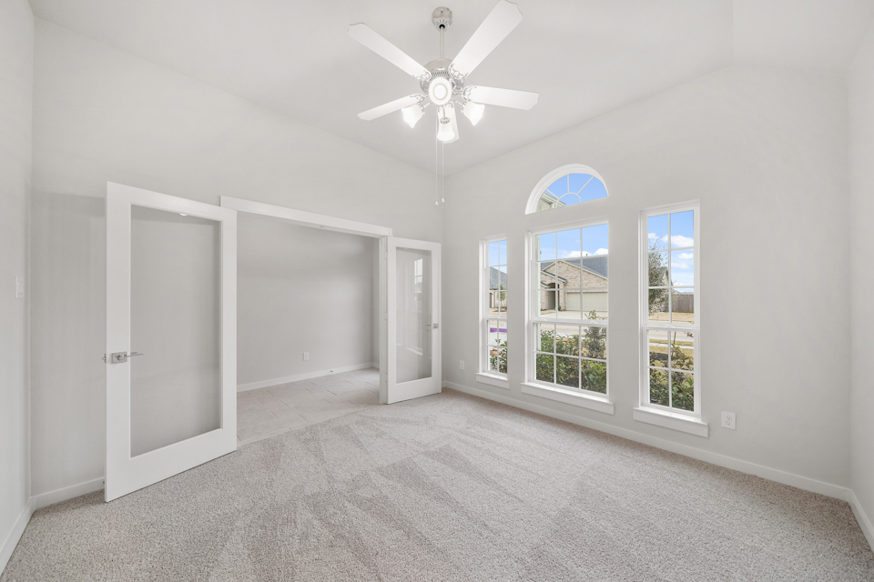 A room with a ceiling fan and a window.