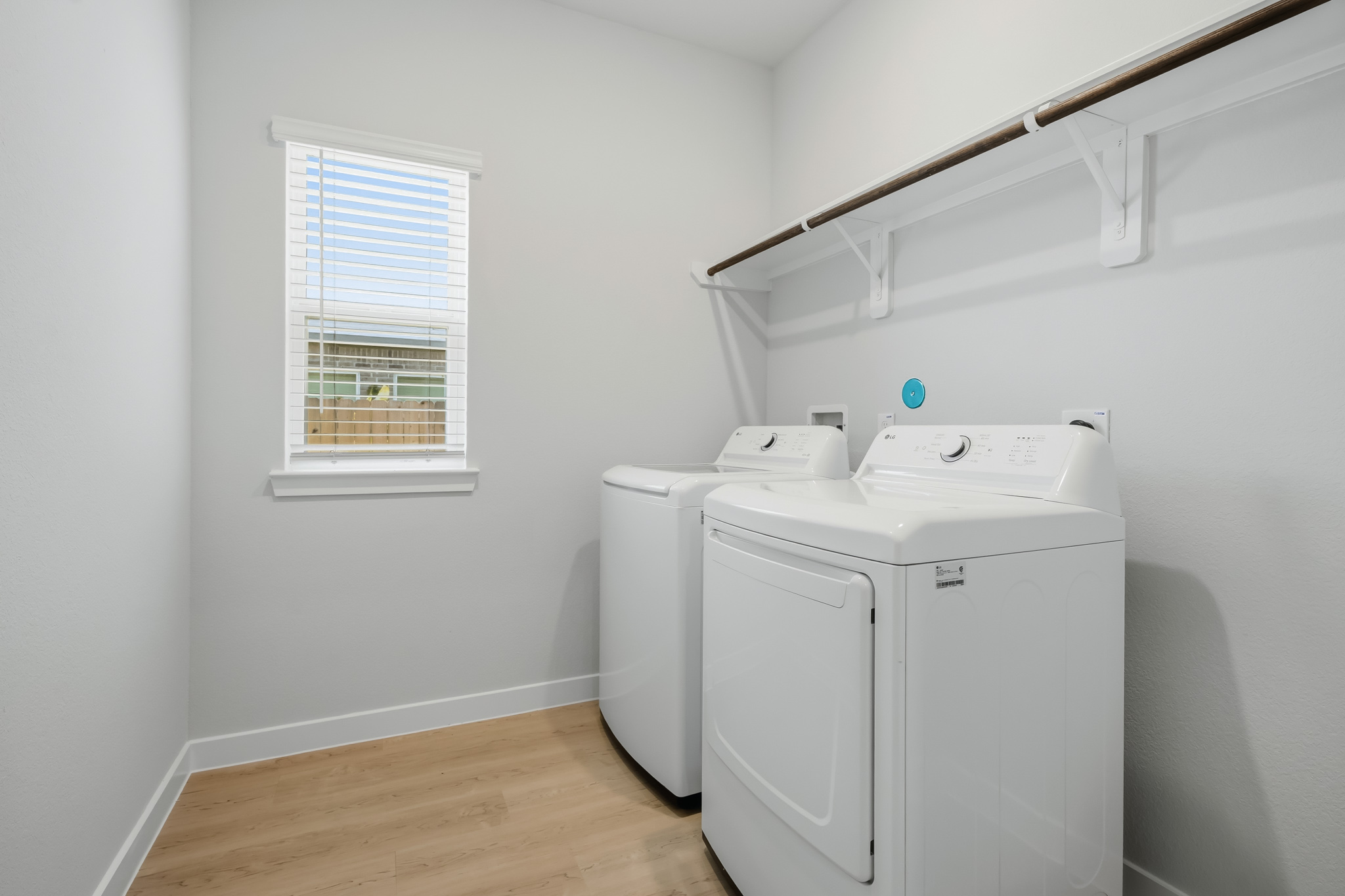 A white laundry room with a white radiator and a window.