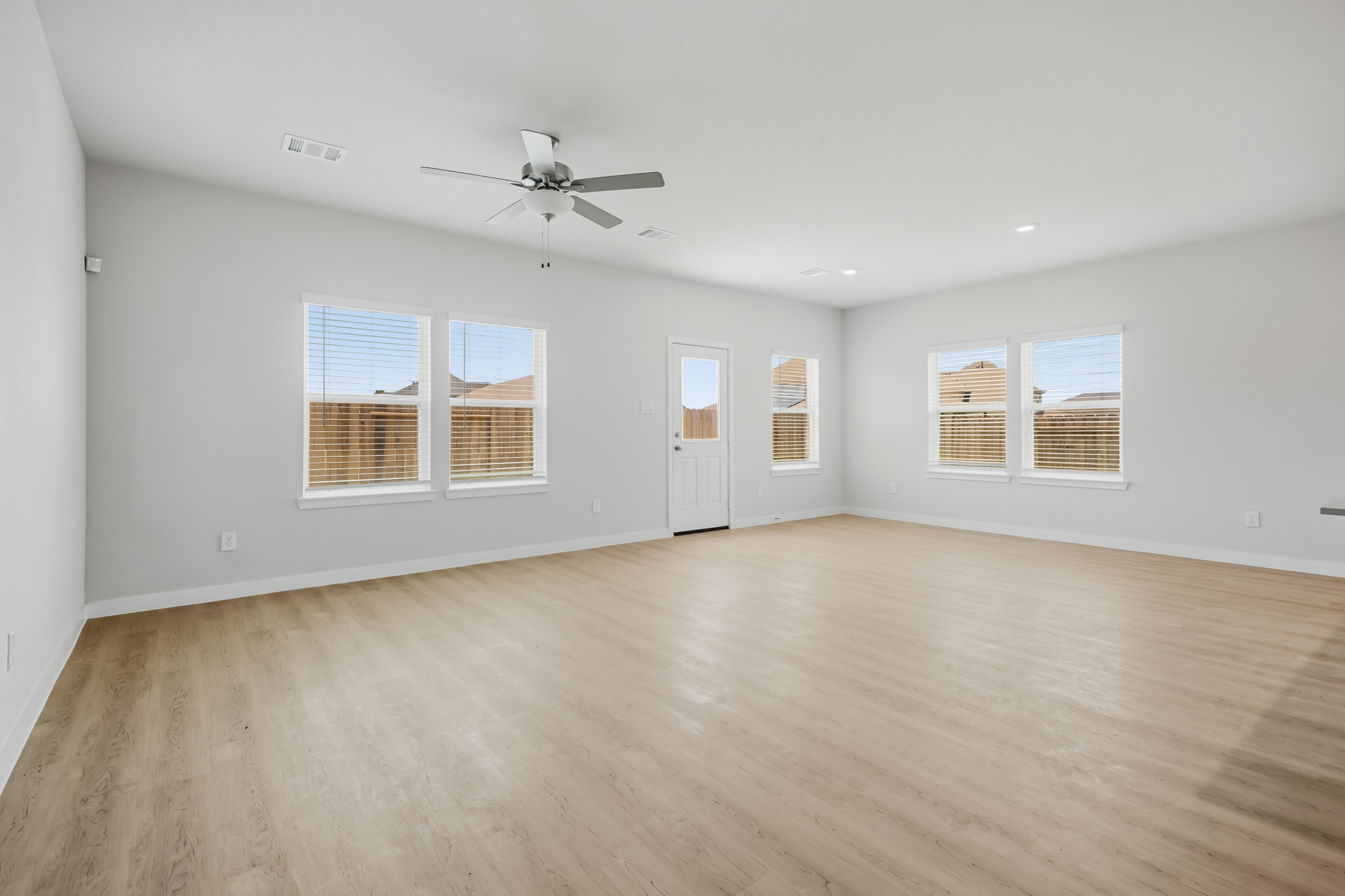 A room with a wood floor and a ceiling fan.