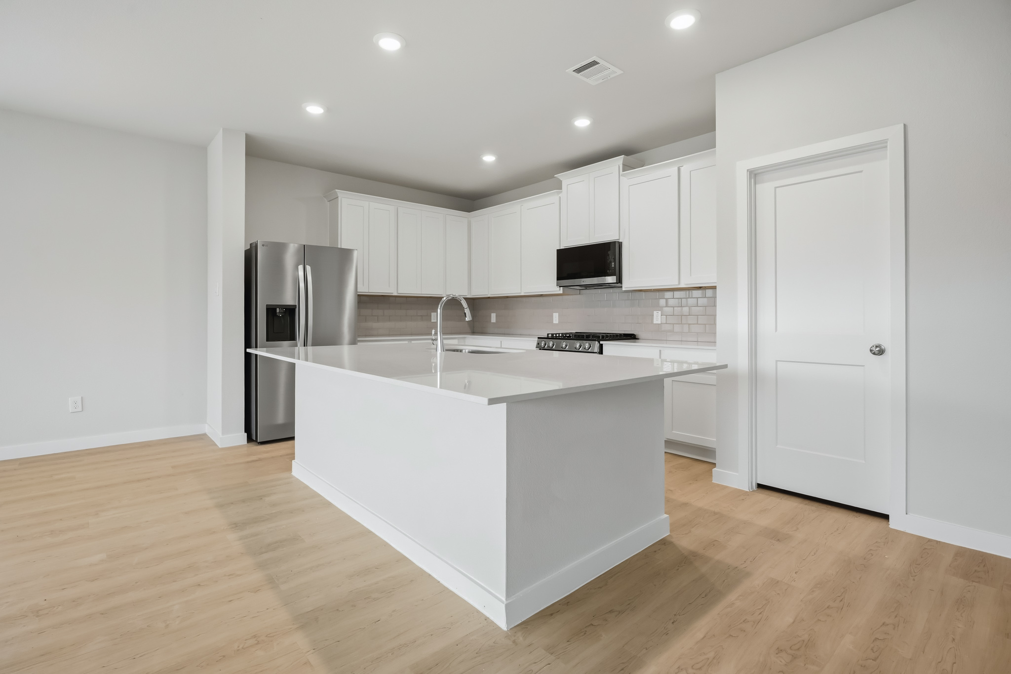 A kitchen with white cabinets.