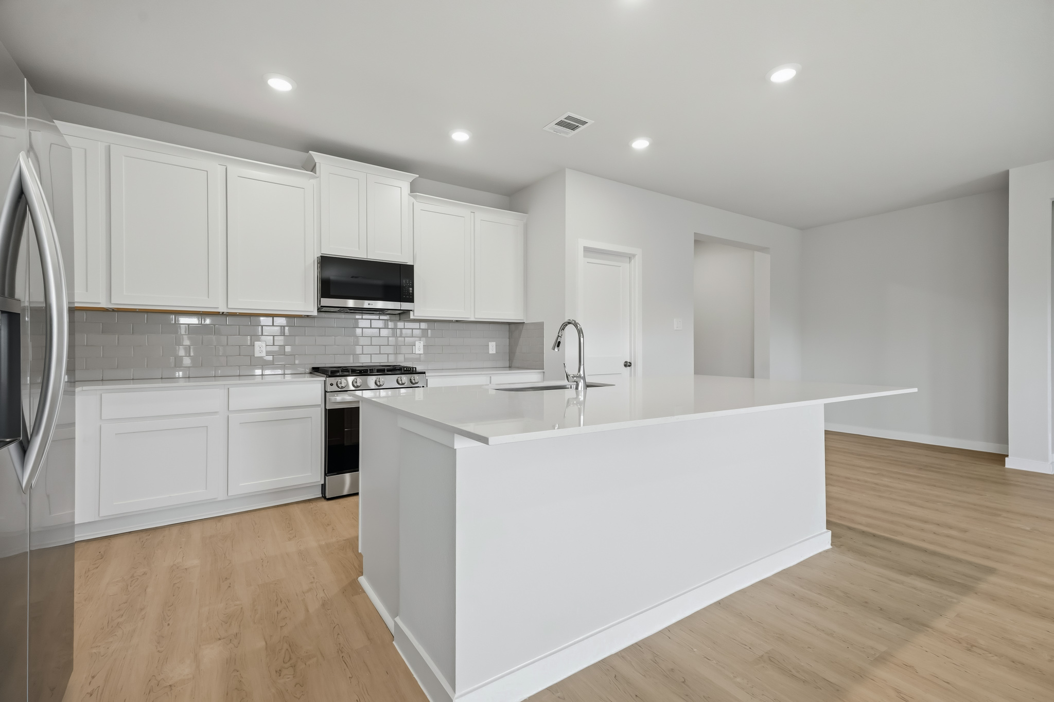 A kitchen with white cabinets.