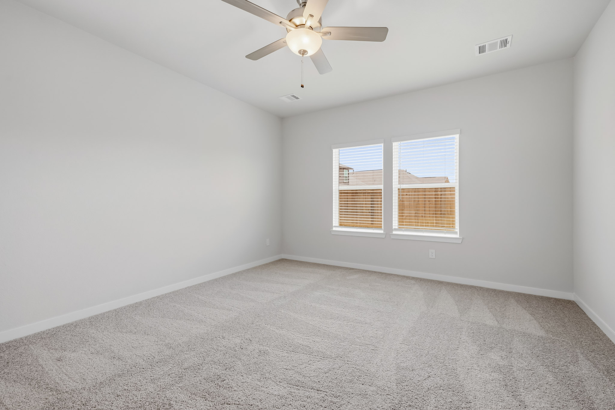A room with a ceiling fan and a window.
