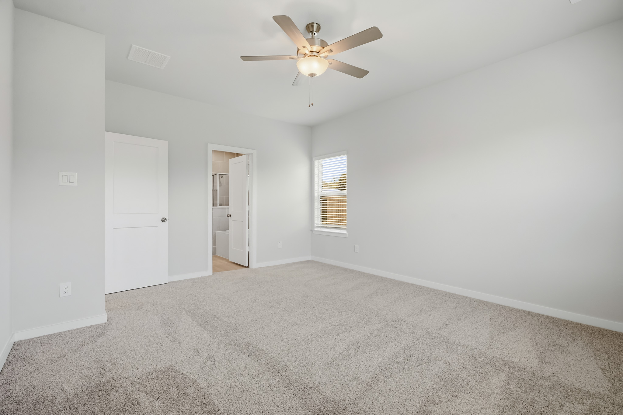A room with a ceiling fan and a door.