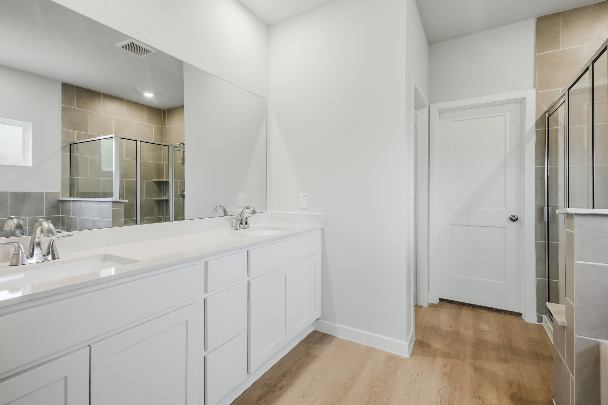 A bathroom with white cabinets.